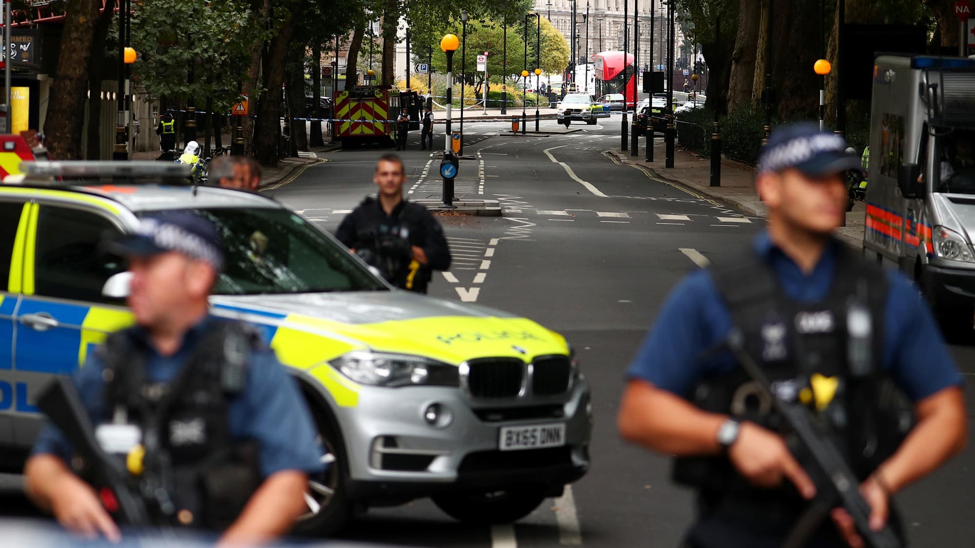 Police officers armed with riffles and bullet-proof vests stand at a cordon after a car crashed outside the Houses of Parliament in Westminster.