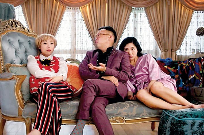 A woman, man and another woman lounge on a luxurious chaise looking stumped by a problem