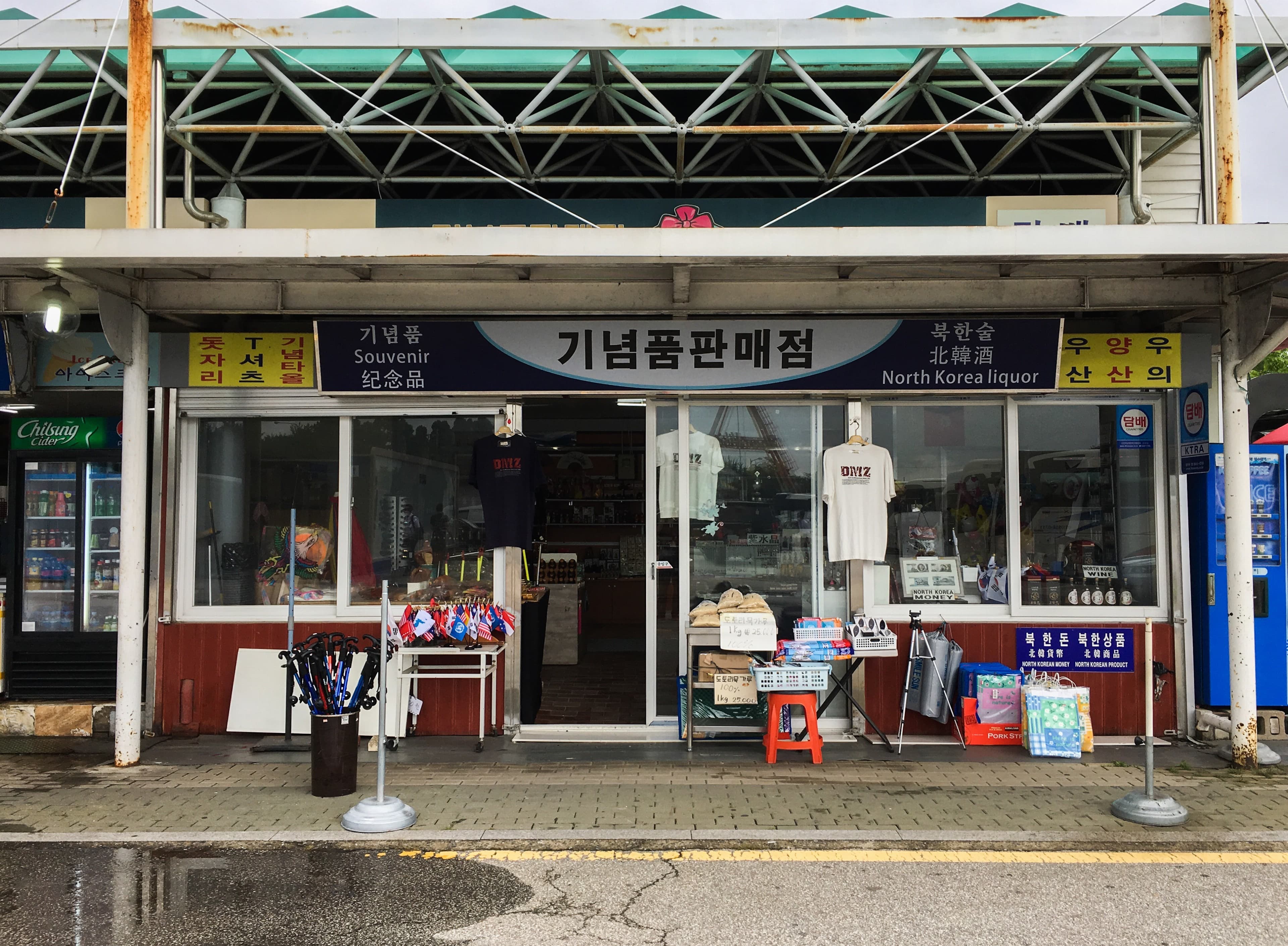 a worn down gift shop with T-shirts out front