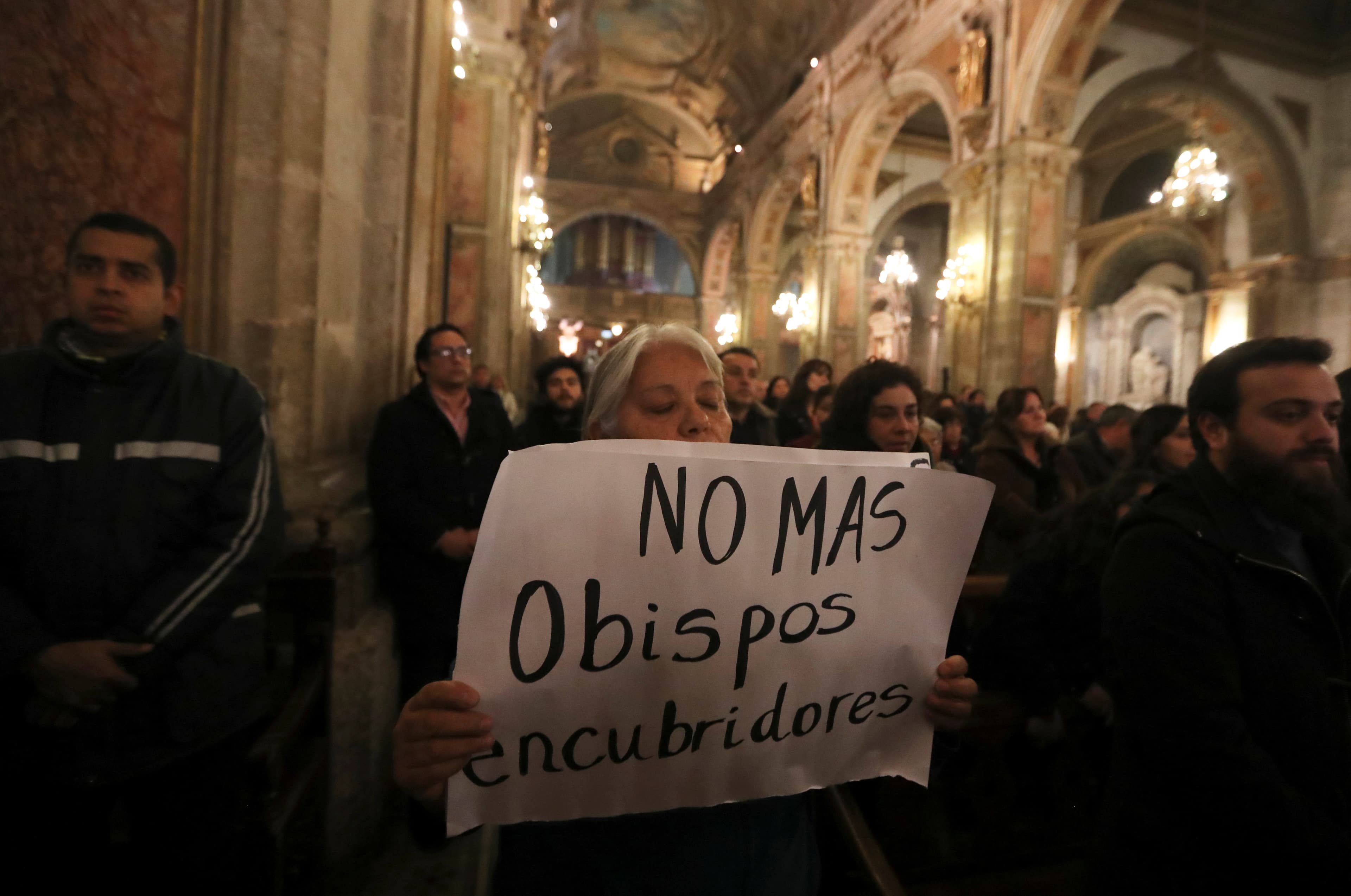 A woman holds a banner that reads, 
