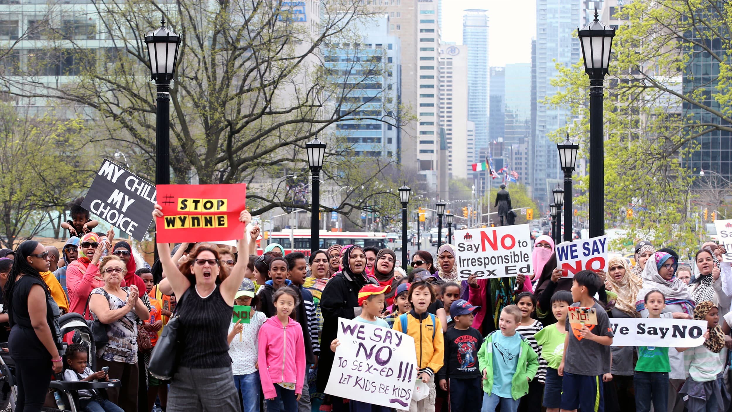 People hold signs reading "no to irresponsible sex ed"