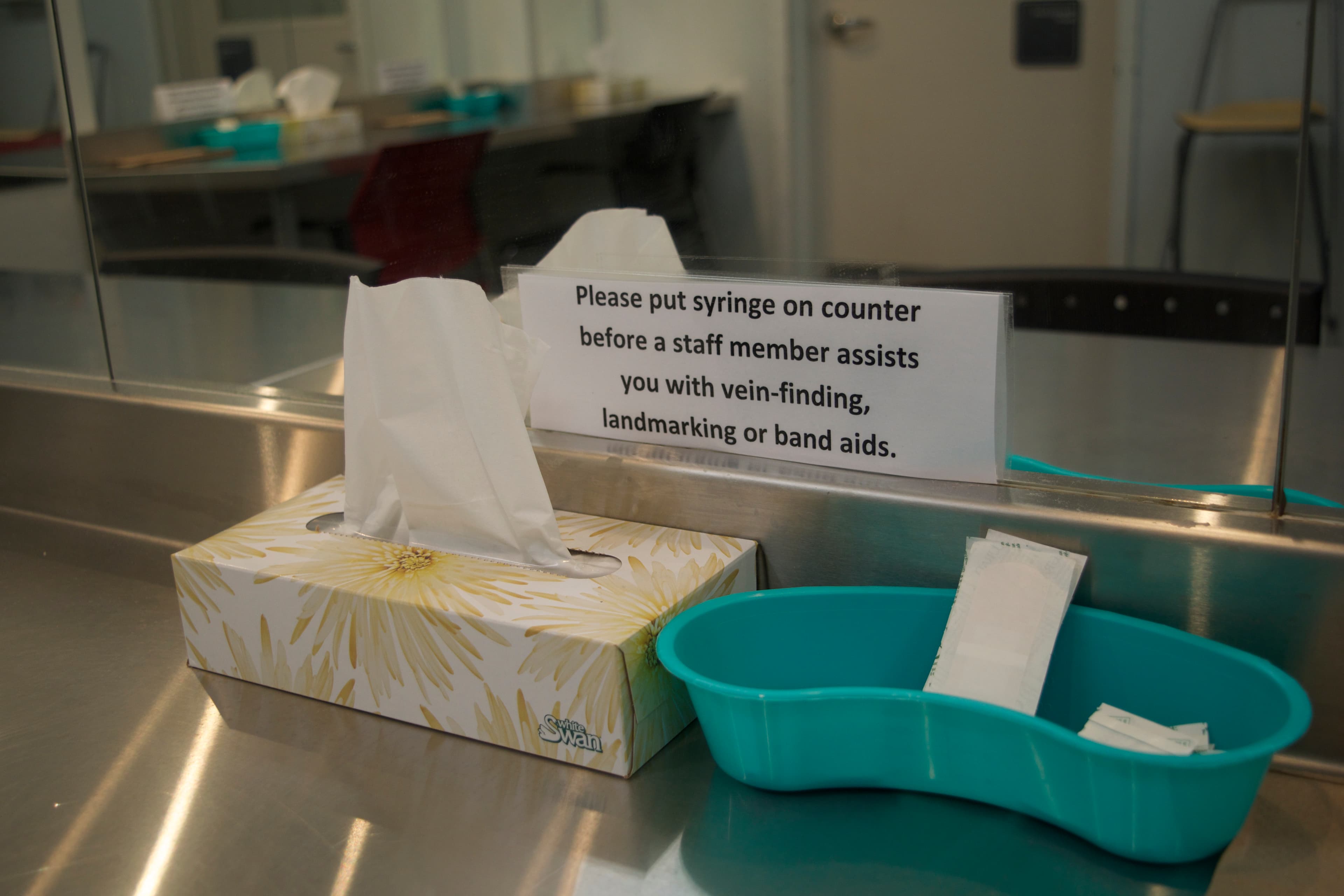 a box of tissues and medical tray on a metal board