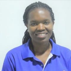Woman in blue shirt looking at camera, smiling