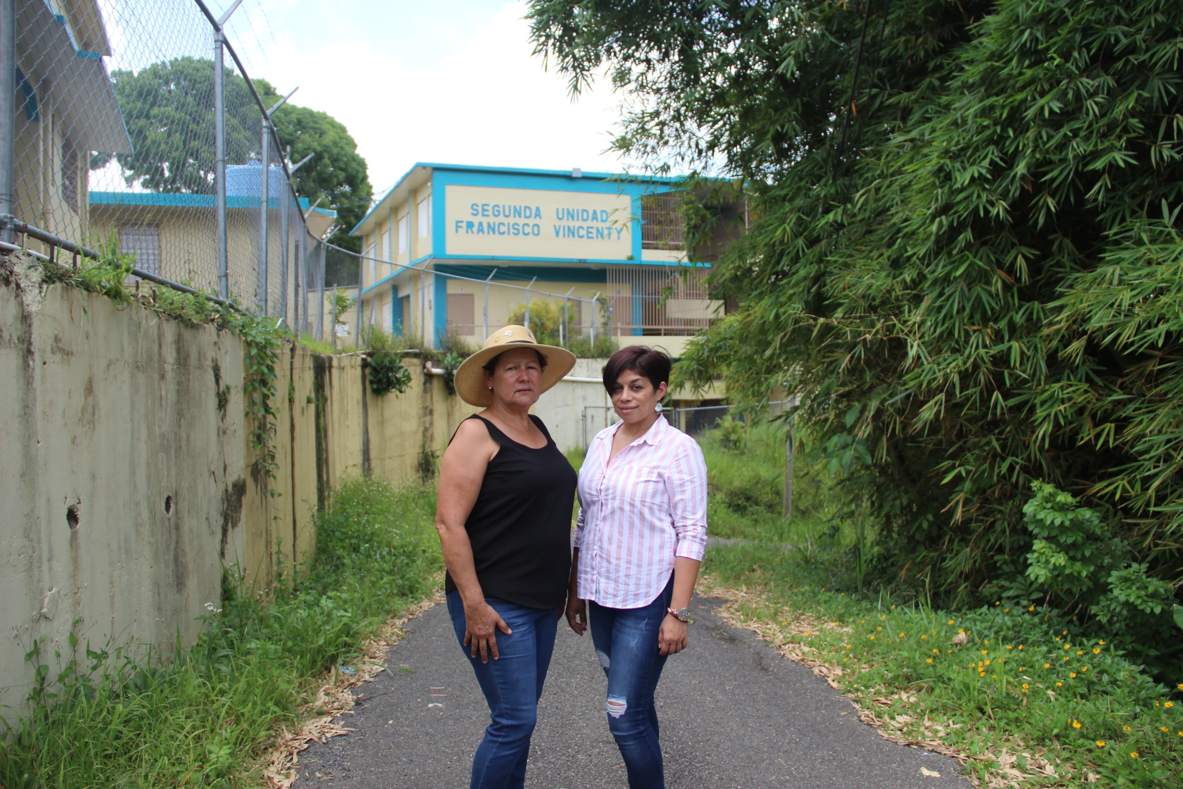 Two women in front of school
