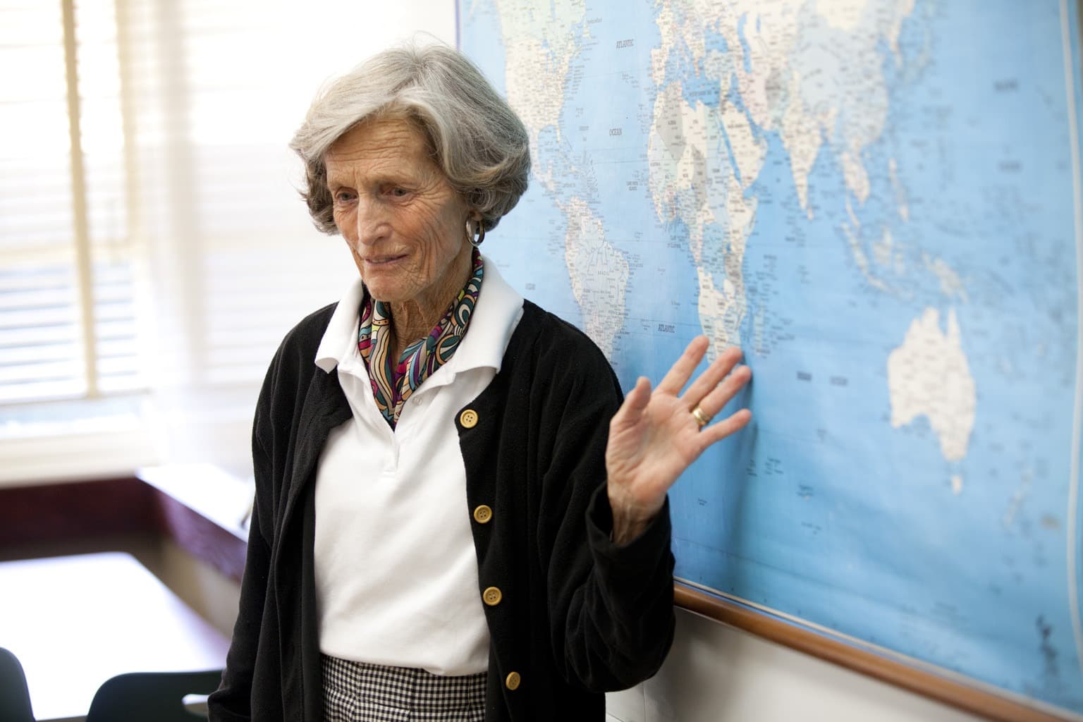 Woman standing in front of map, speaking