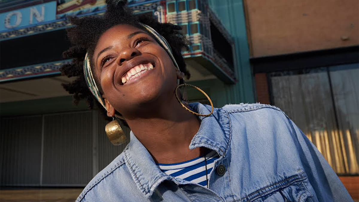 Olympia Auset looks up at the sky and smiles.