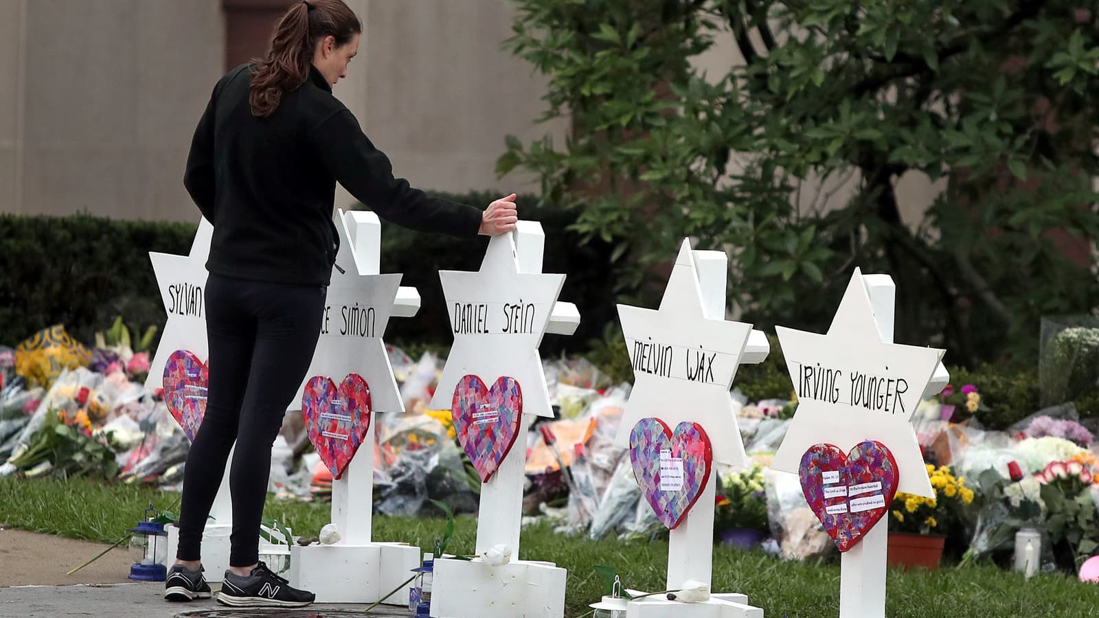 A woman touches a white Jewish star memorial for Tree of Life victim