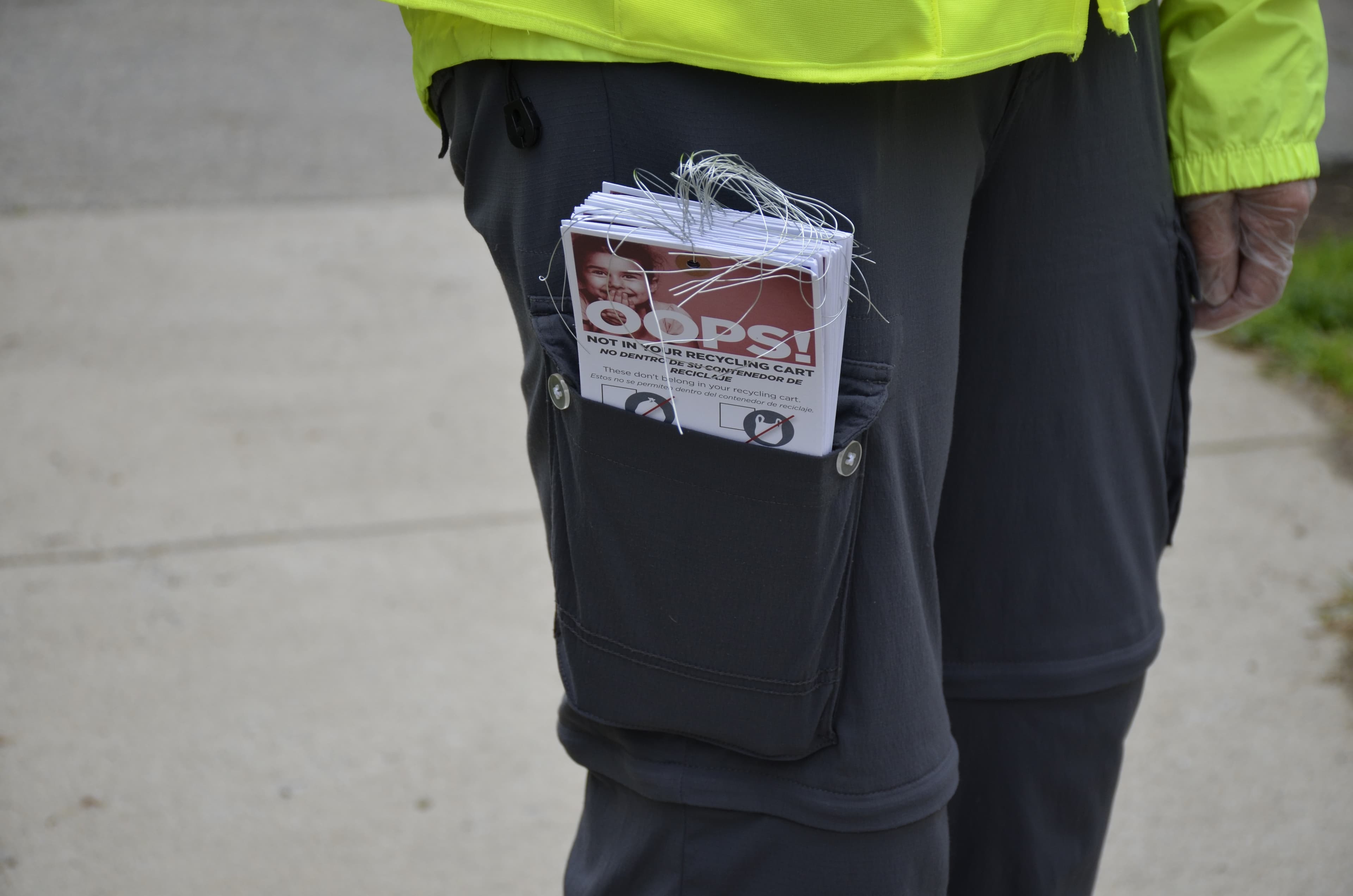 Julia Greene with the city of Lynn, Mass. carries “Oops!” tags to put on unclean recycling bins, explaining some basic rules for better recycling. The tags were developed by The Recycling Partnership.