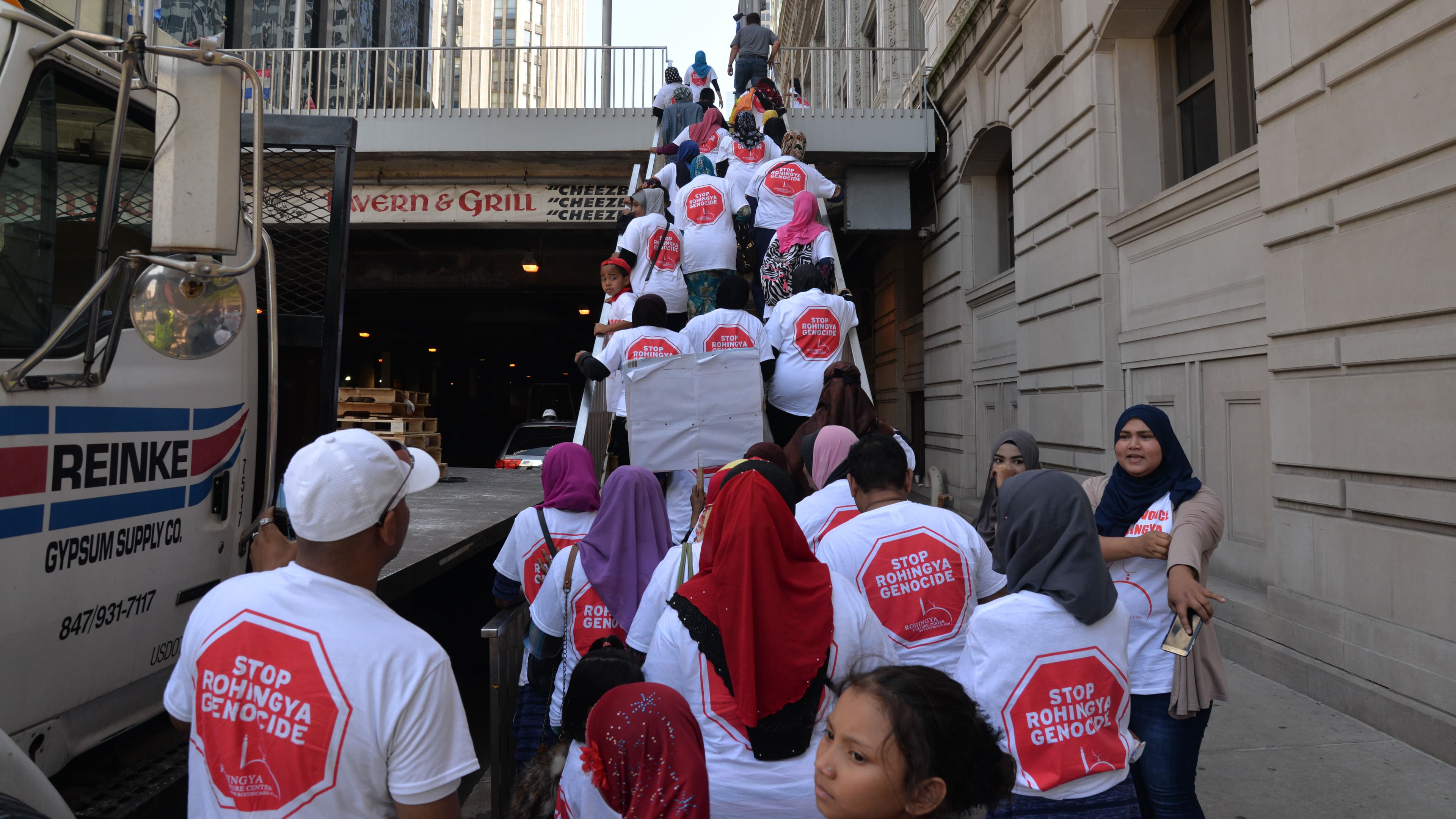 A group of people heading to a demonstration are going up a stairway in downtown Chicago.