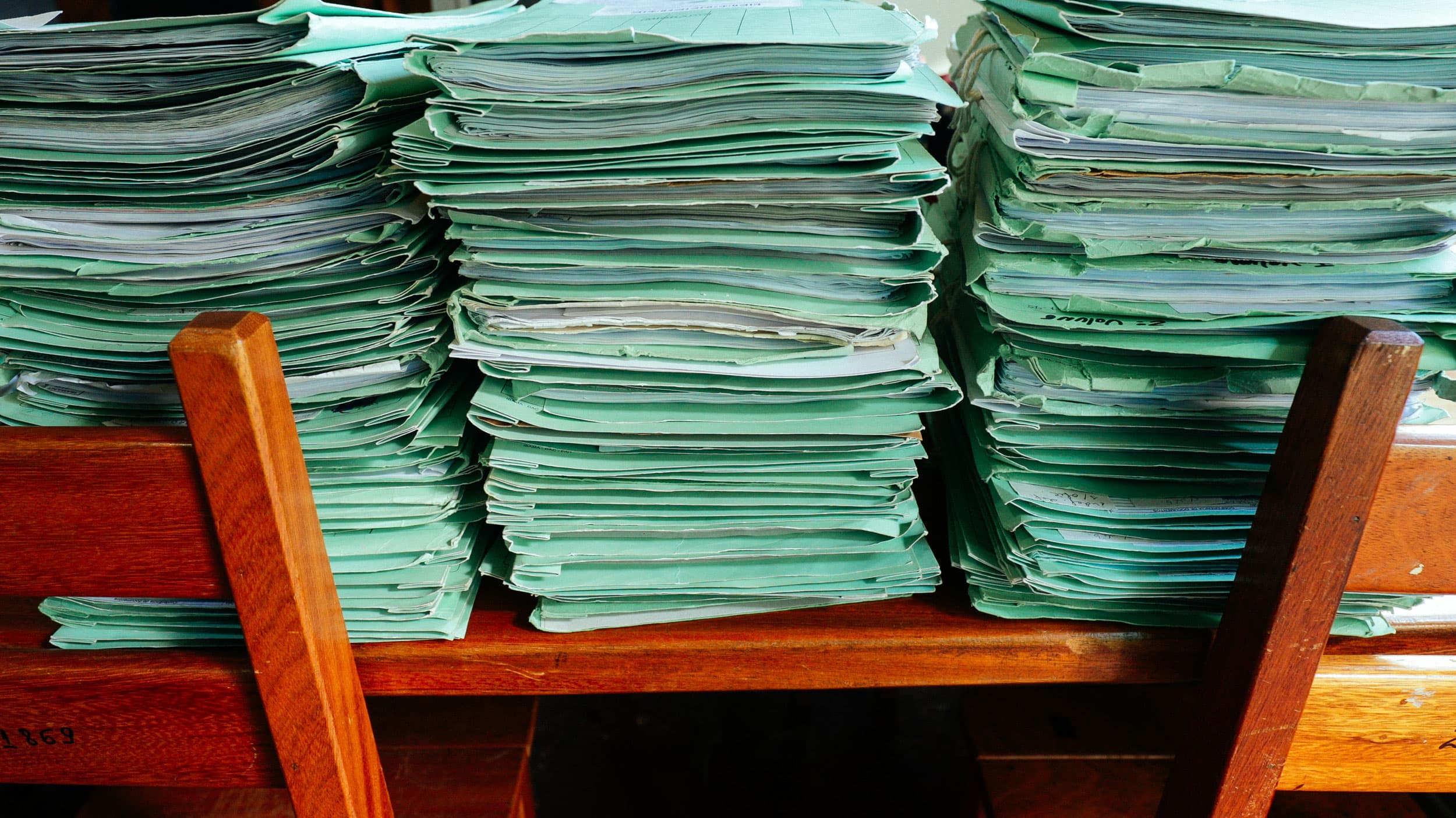 Piles of boxes contain folders of mostly unpaid fines for deforestation violations, Selva says.