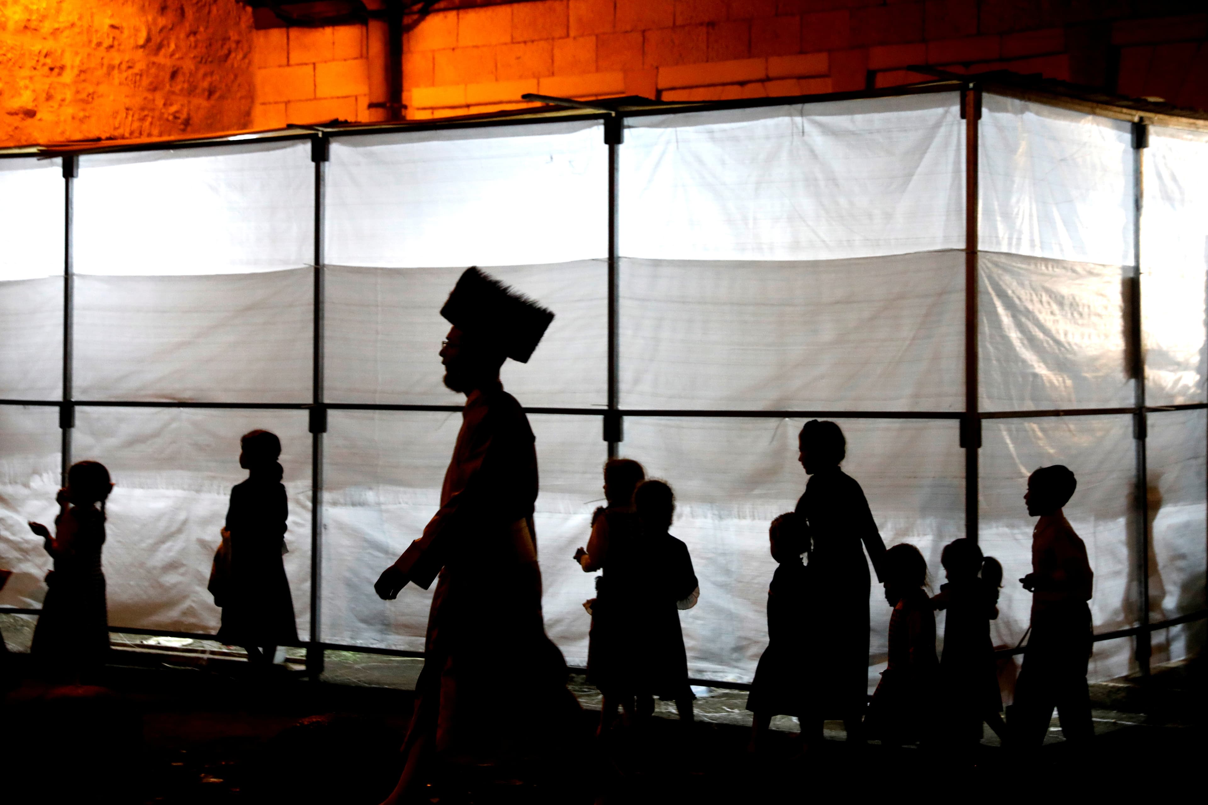 the silhouettes of members of the ultra orthodox community in Jerusalem