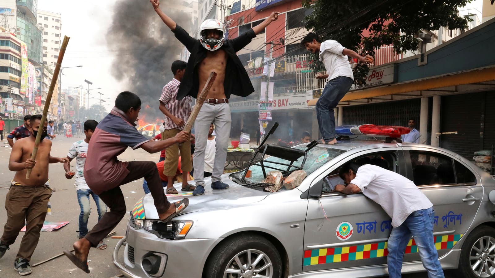 Five young Bangladesh Nationalist Party activists vandalize a police vehicle with batons