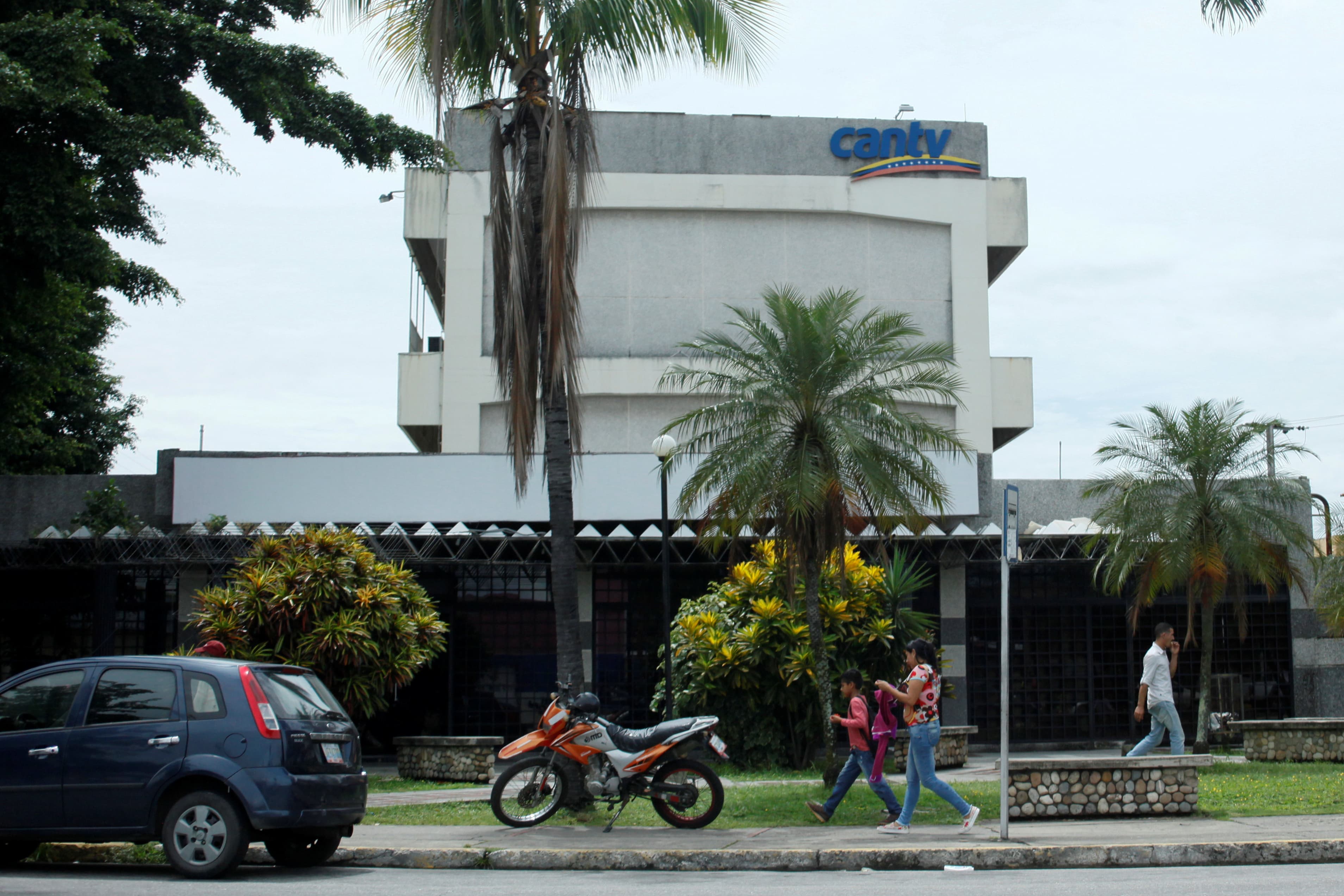 People walk past a CANTV office building