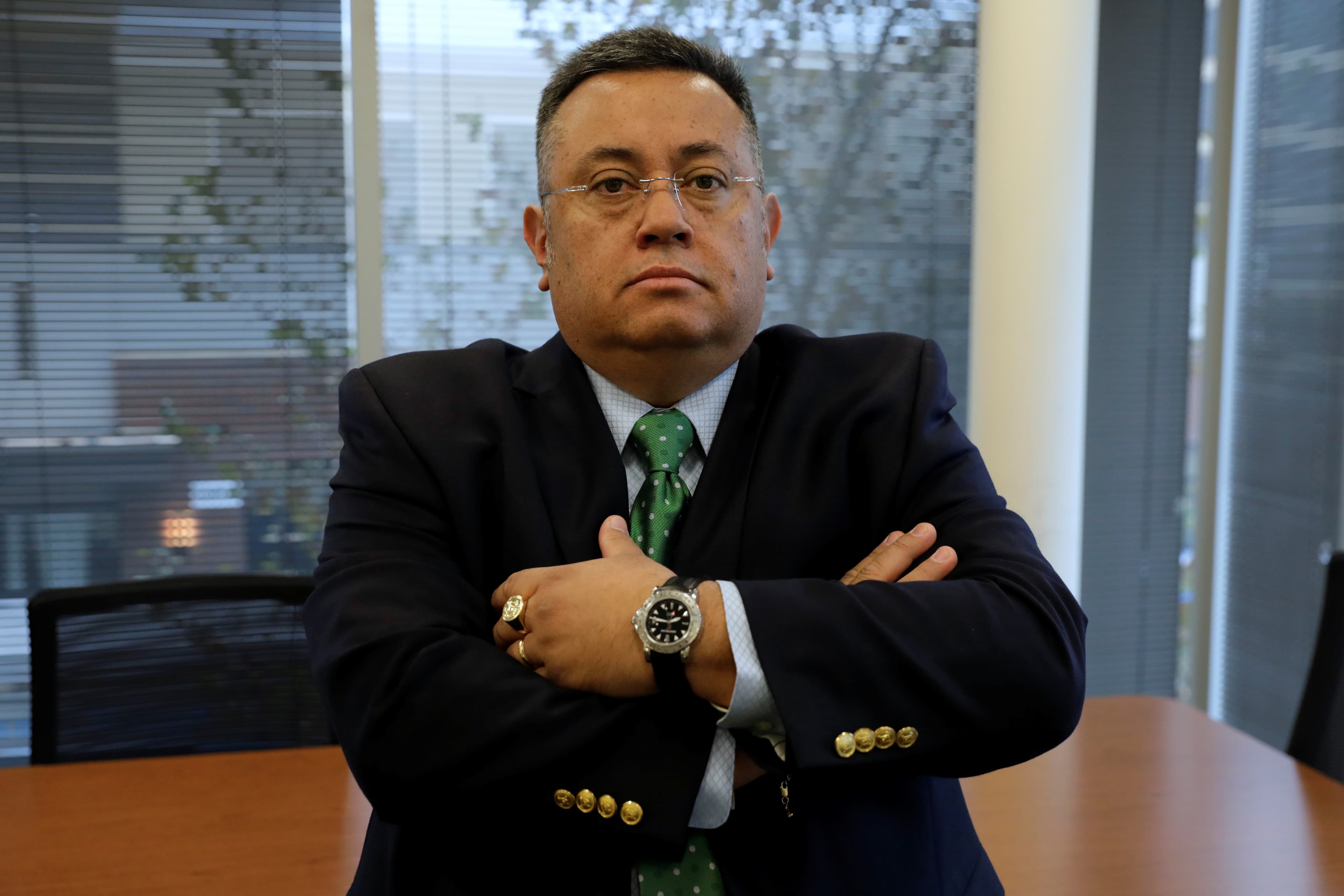 Anthony Daquin sitting on a desk, crossing his arms