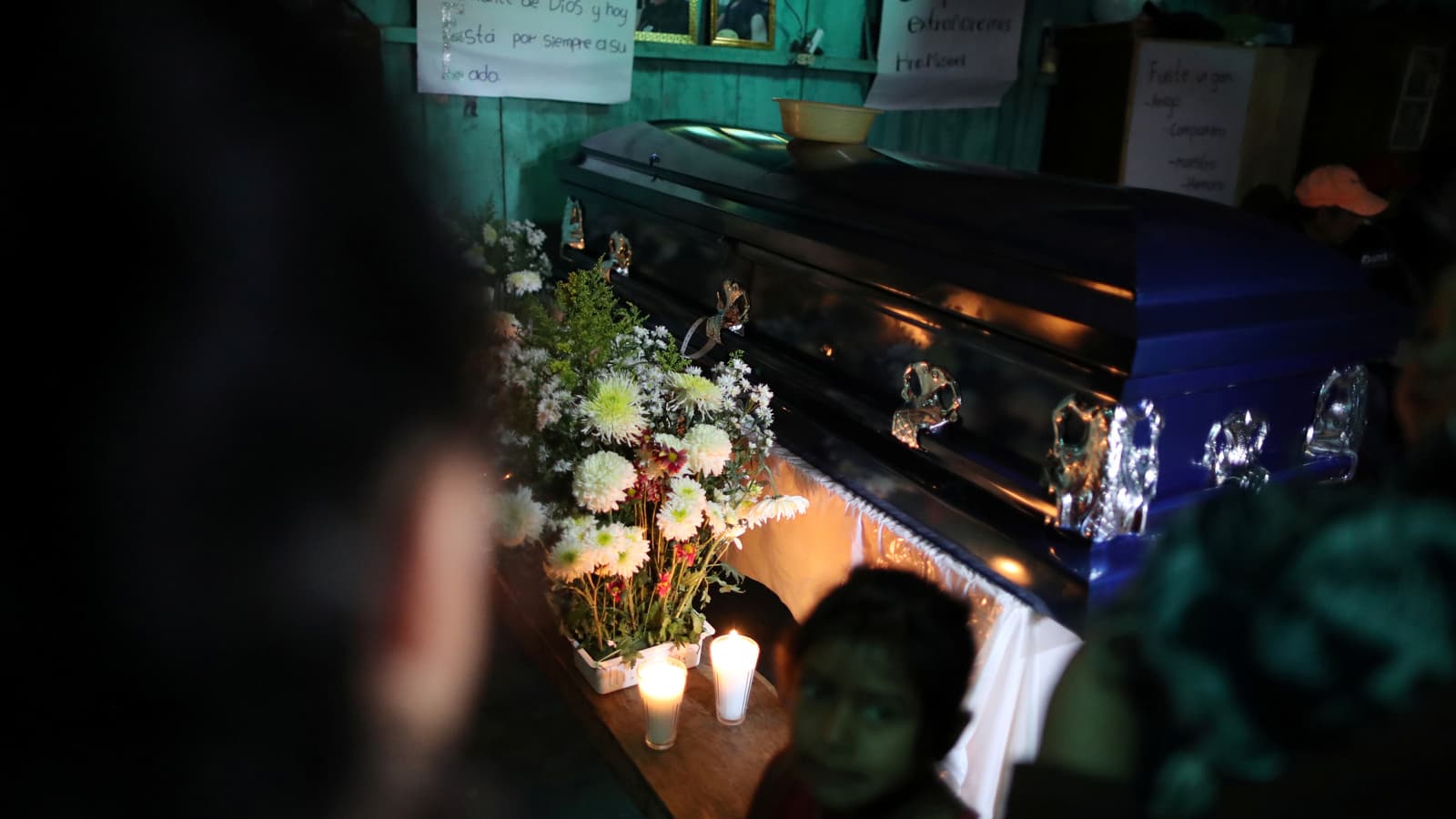 A blue coffin with flowers inside a home in Guatemala.