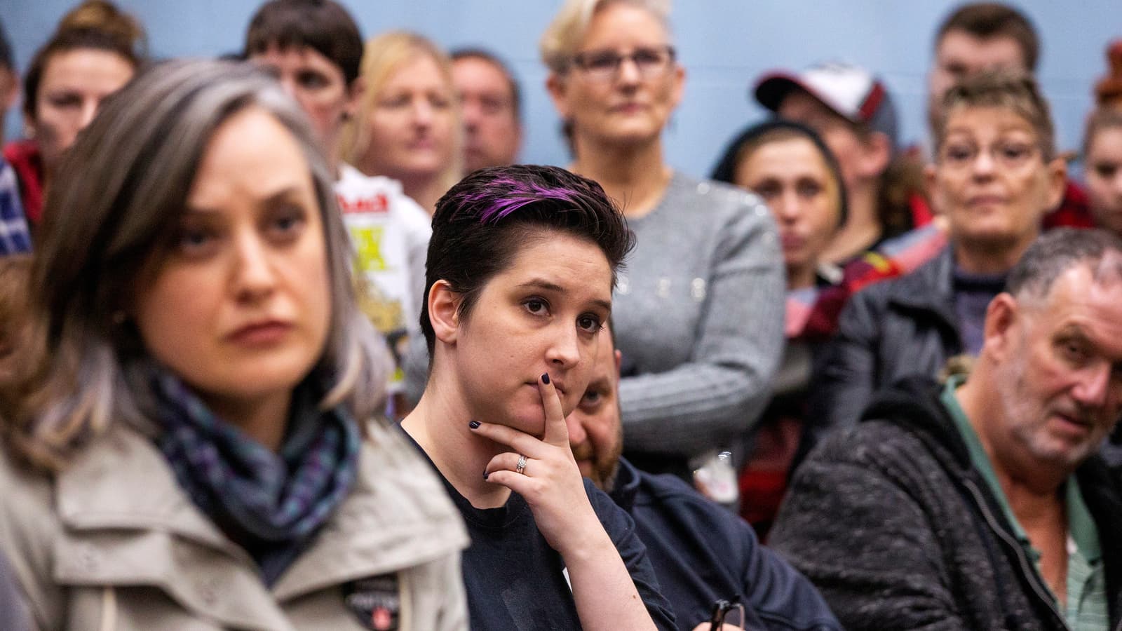 Three GM employees at a meeting with worried faces.