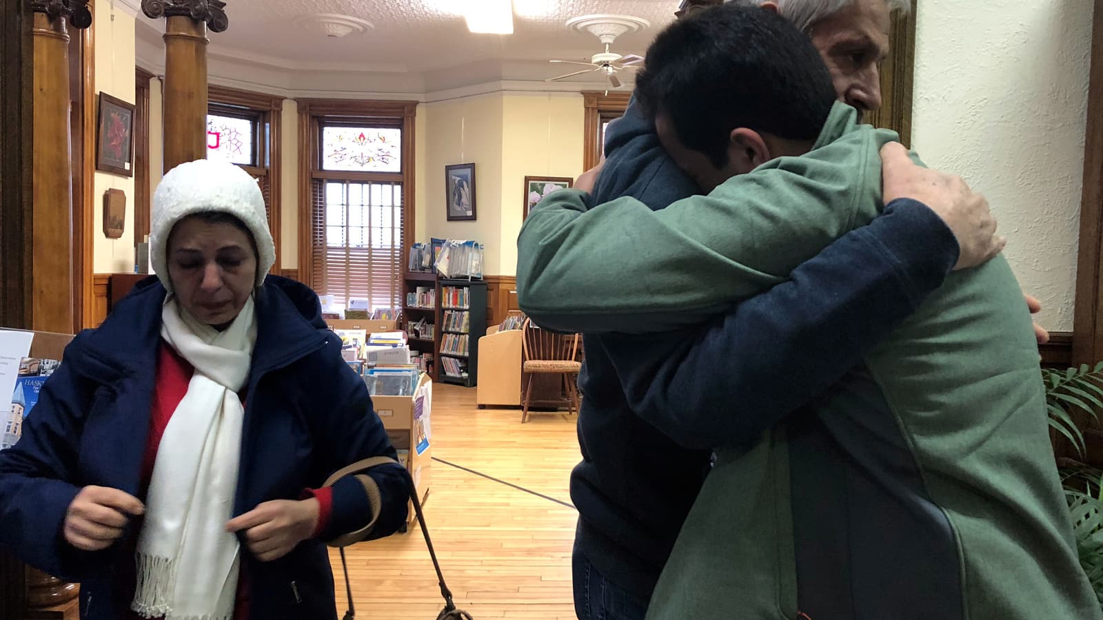 A man embraces his father at a library.