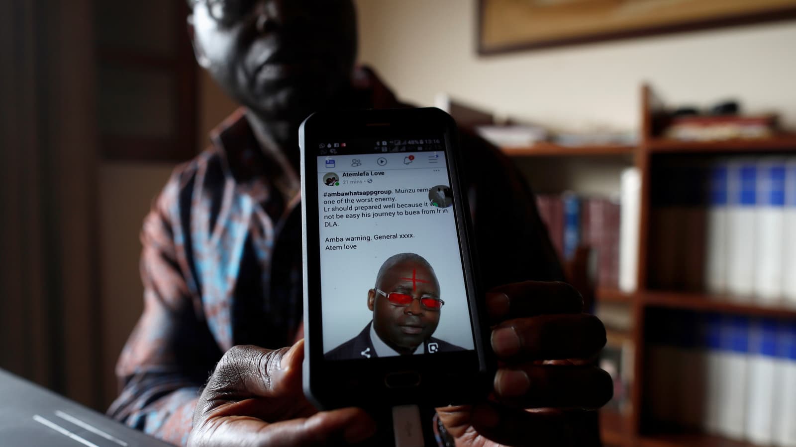 A former UN official campaigning for peace shows a threatening message posted against him on social media by separatists