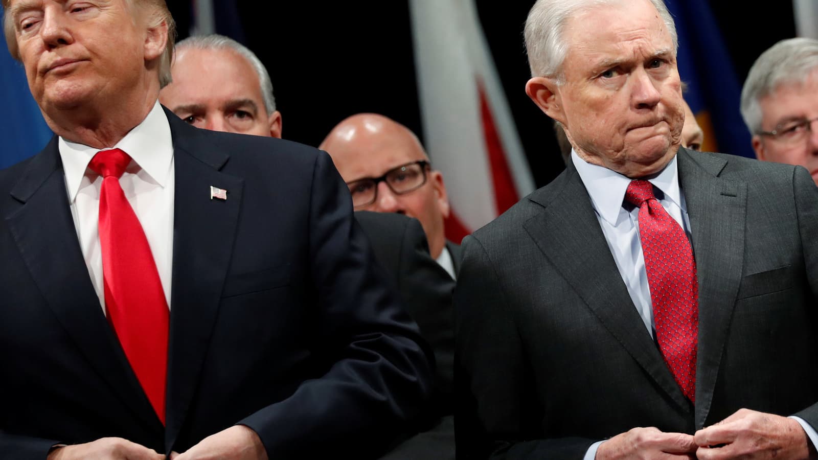 Trump and Sessions button their blue coats as they stand for the national anthem.