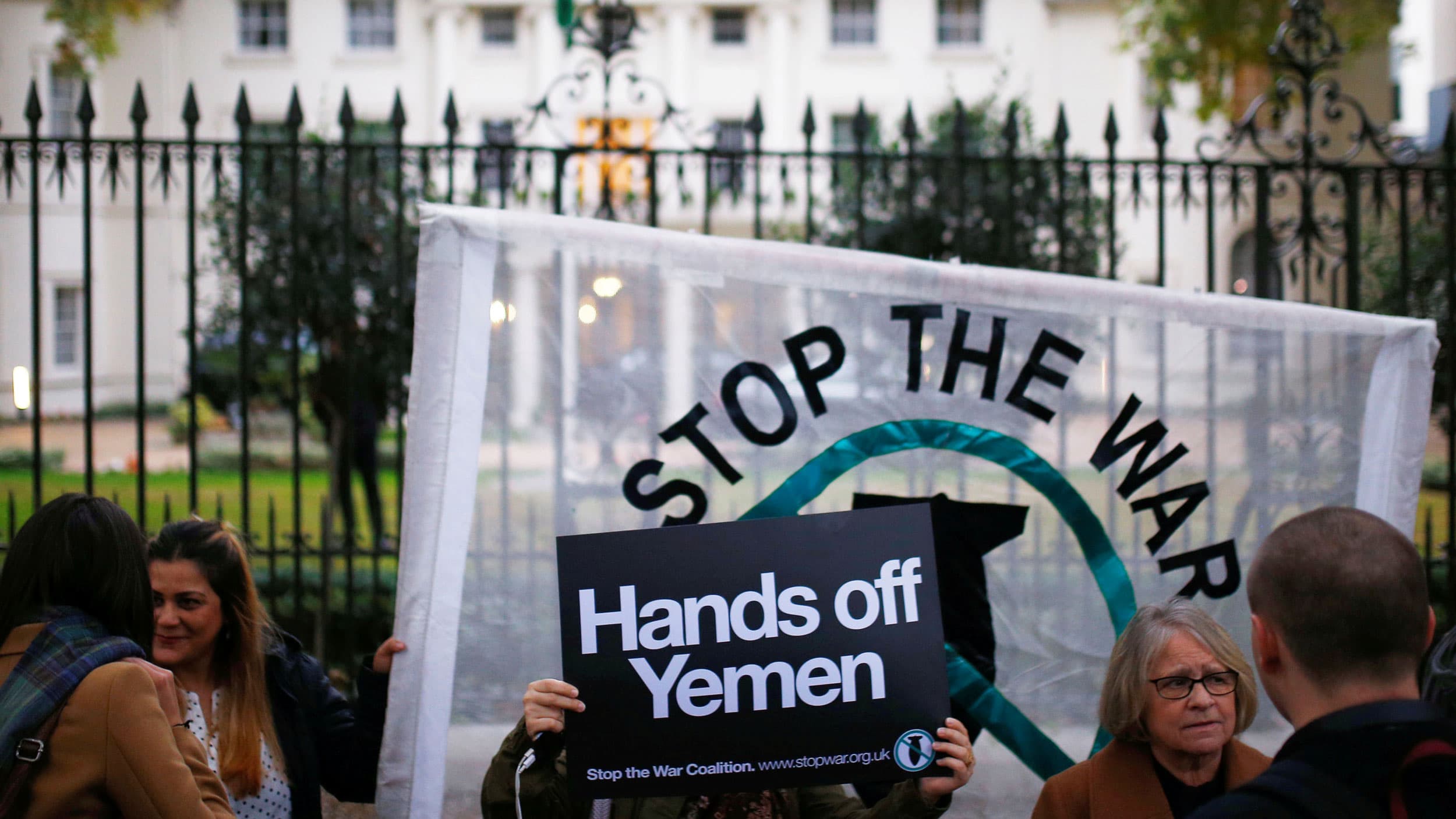 Demonstrators from the Stop The War Coalition stage a protest, holding signs.