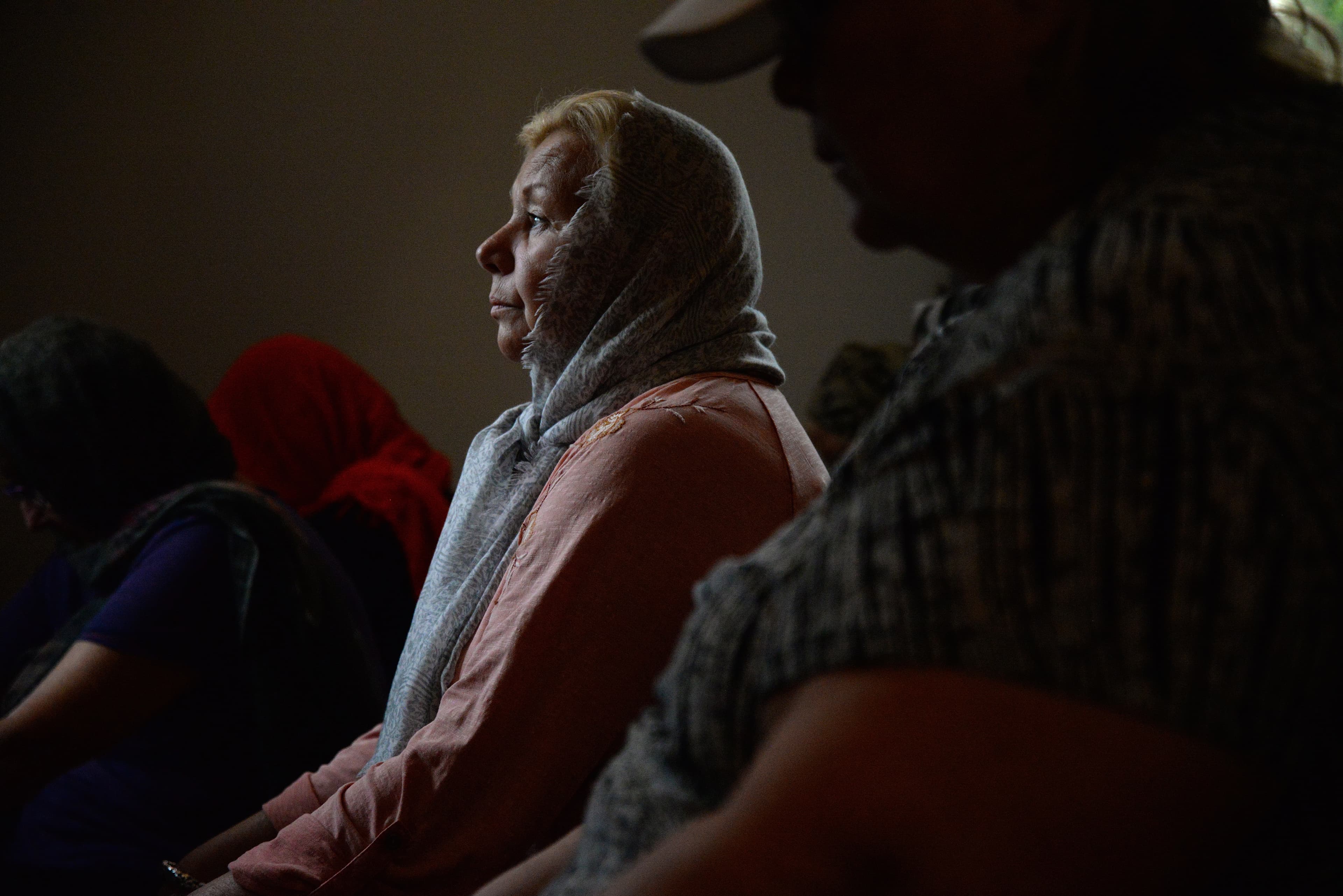 Woman kneeling looking forward, profile view