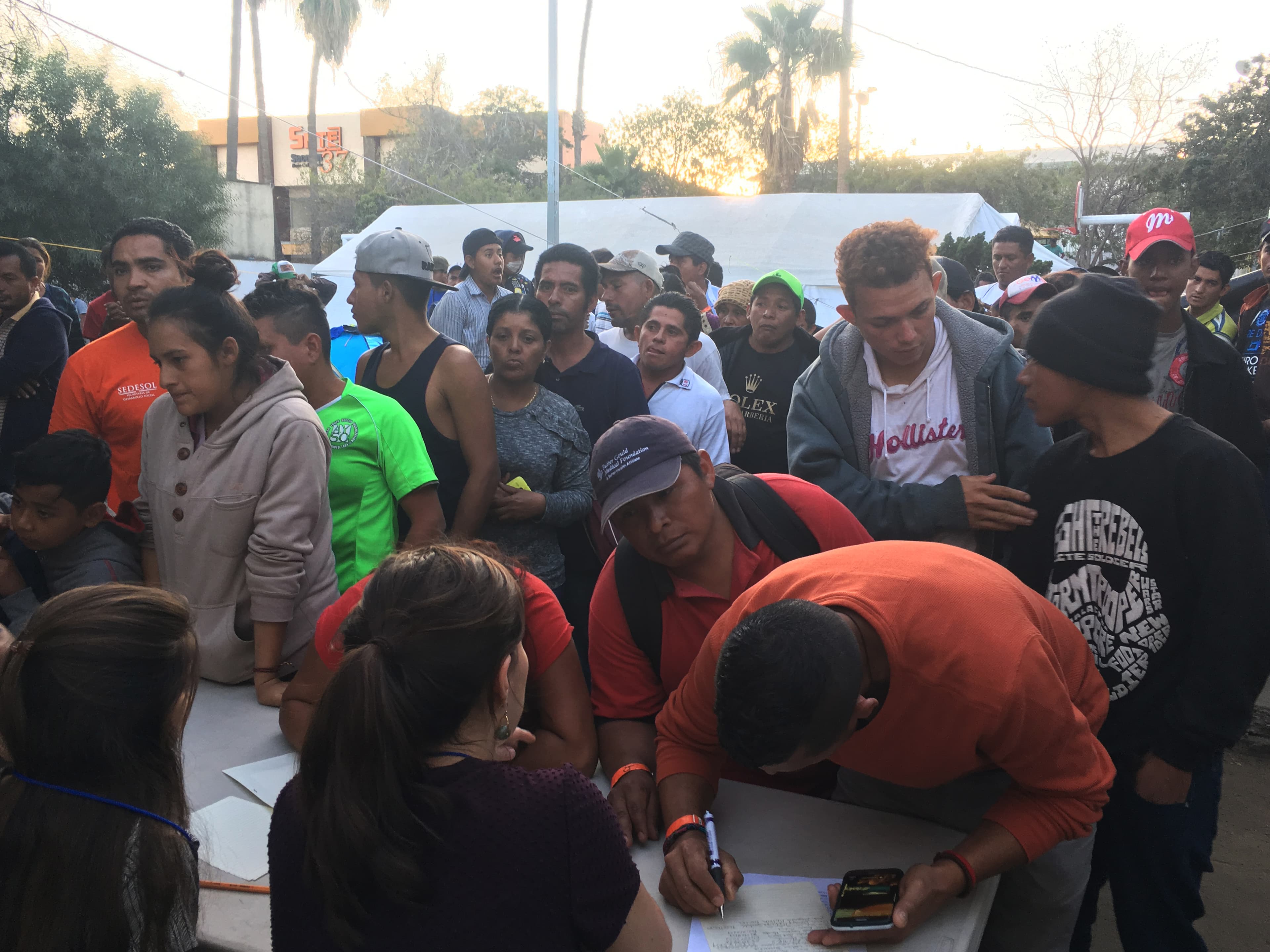 Dozens of migrants wait in line to talk to three attorneys from New York University. 