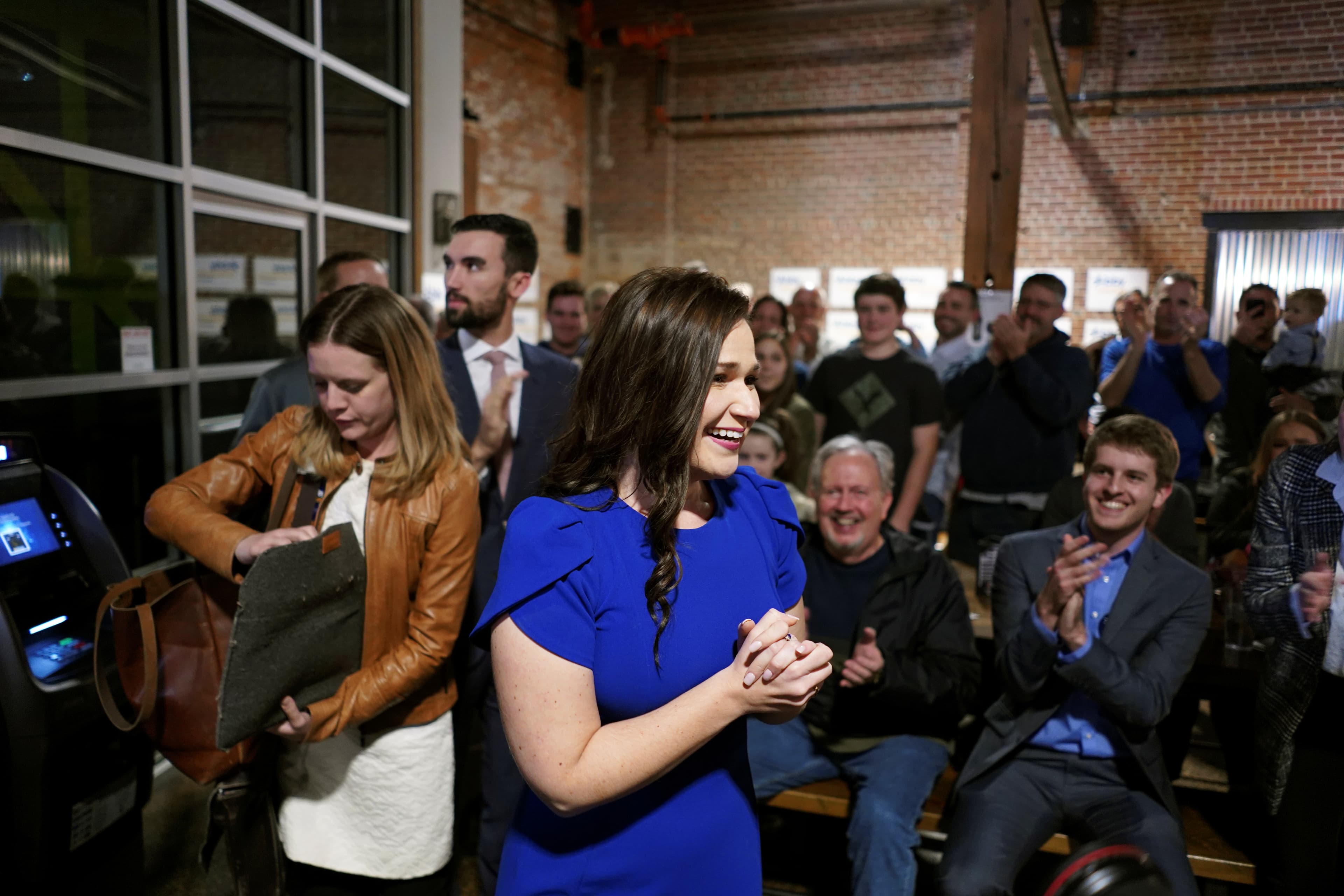 Abby Finkenauer smiles with her hands clasped