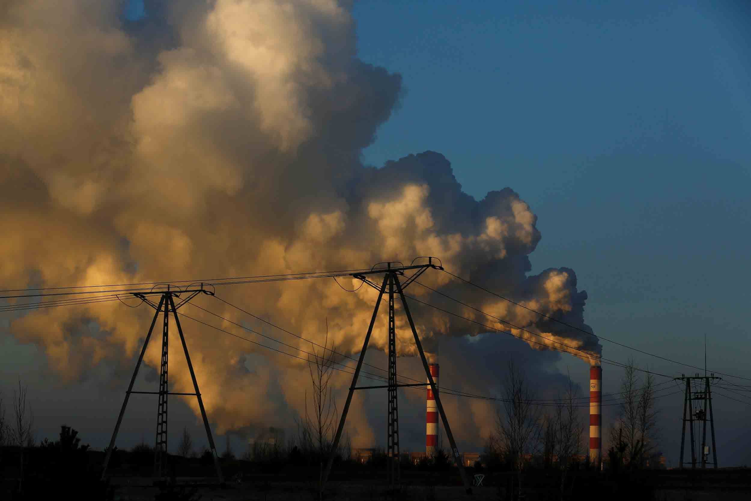 Clouds of smoke and steam rise into the sky from smokestacks