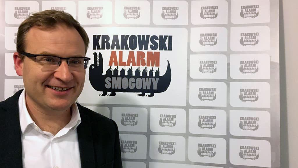 A man poses in front a screen for a photo.