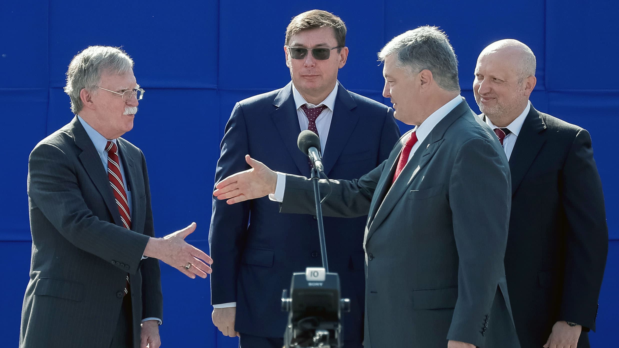 Two men extend their hands for a handshake
