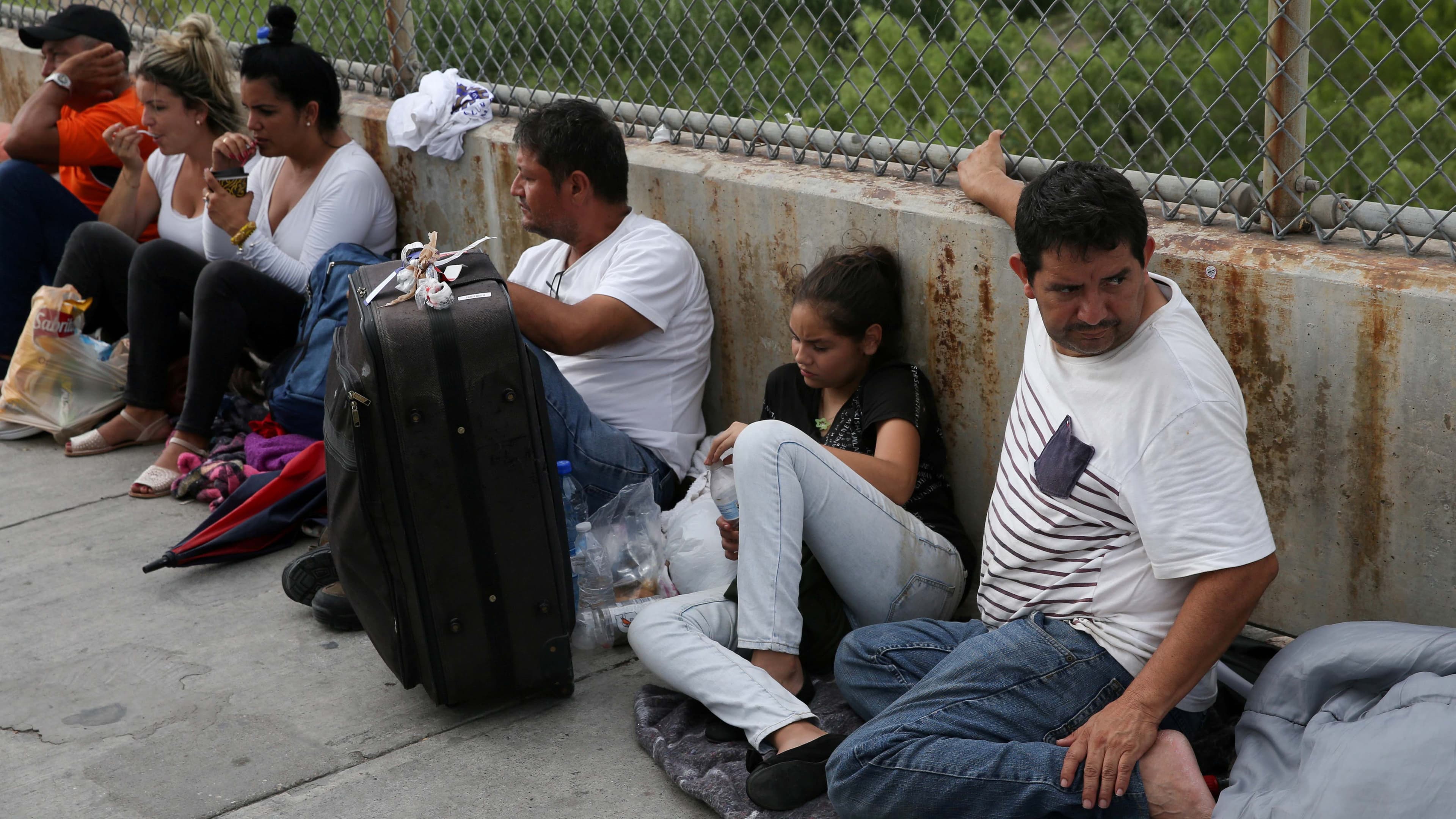 Men and women sit along a bridge
