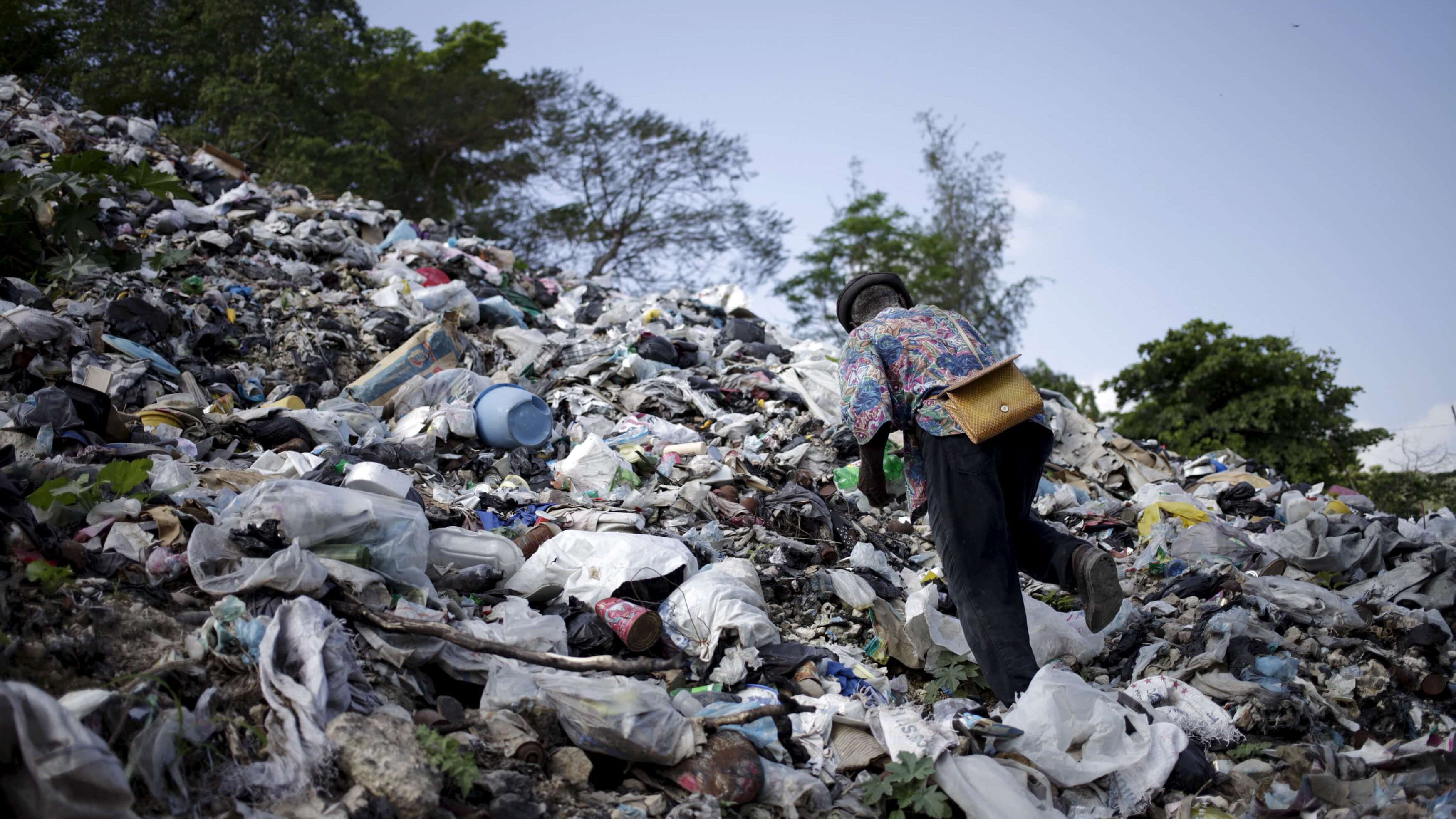 a man climbs a pile of garbage