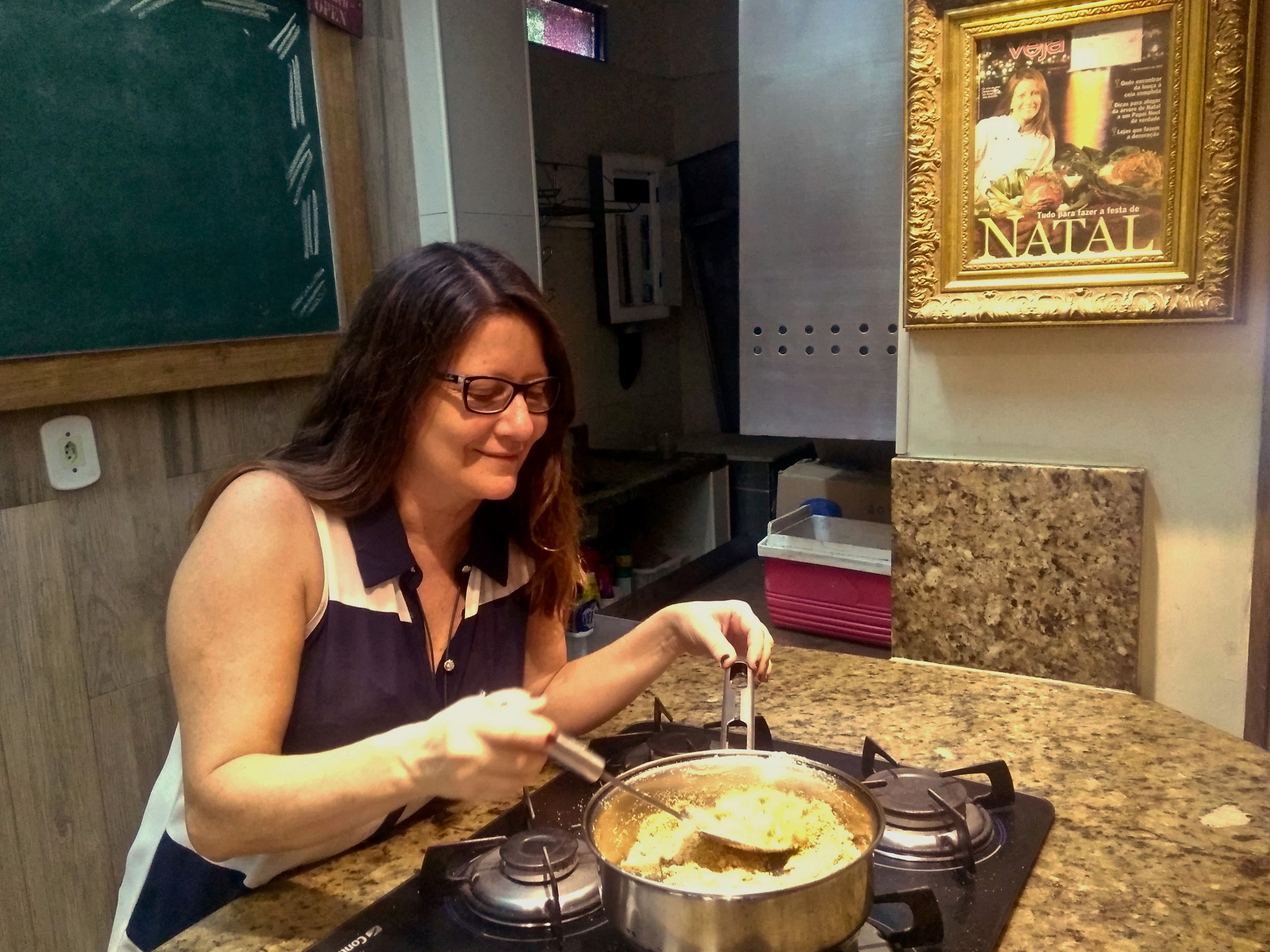 a woman with dark hair and a tank top sits over a pot