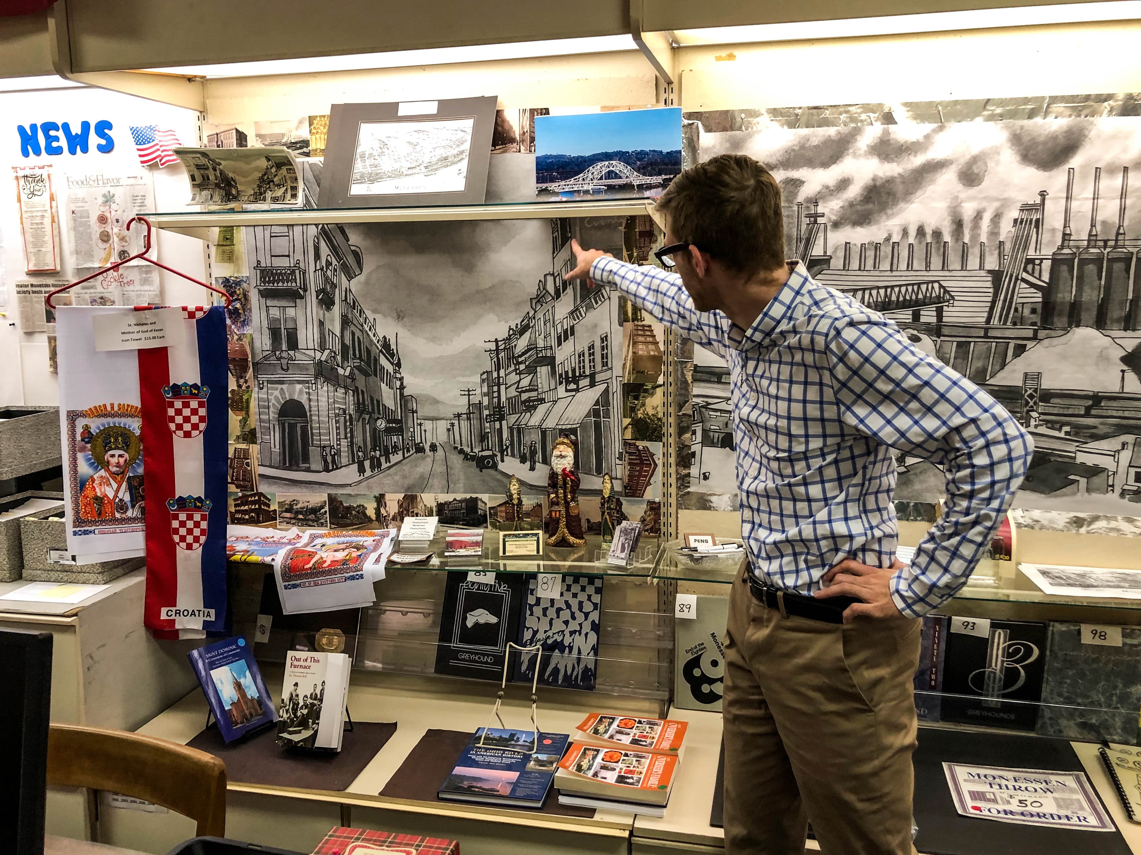 Mayor Matt Shorraw points to a drawing of downtown Monessen, Pennsylvania, during more prosperous times.