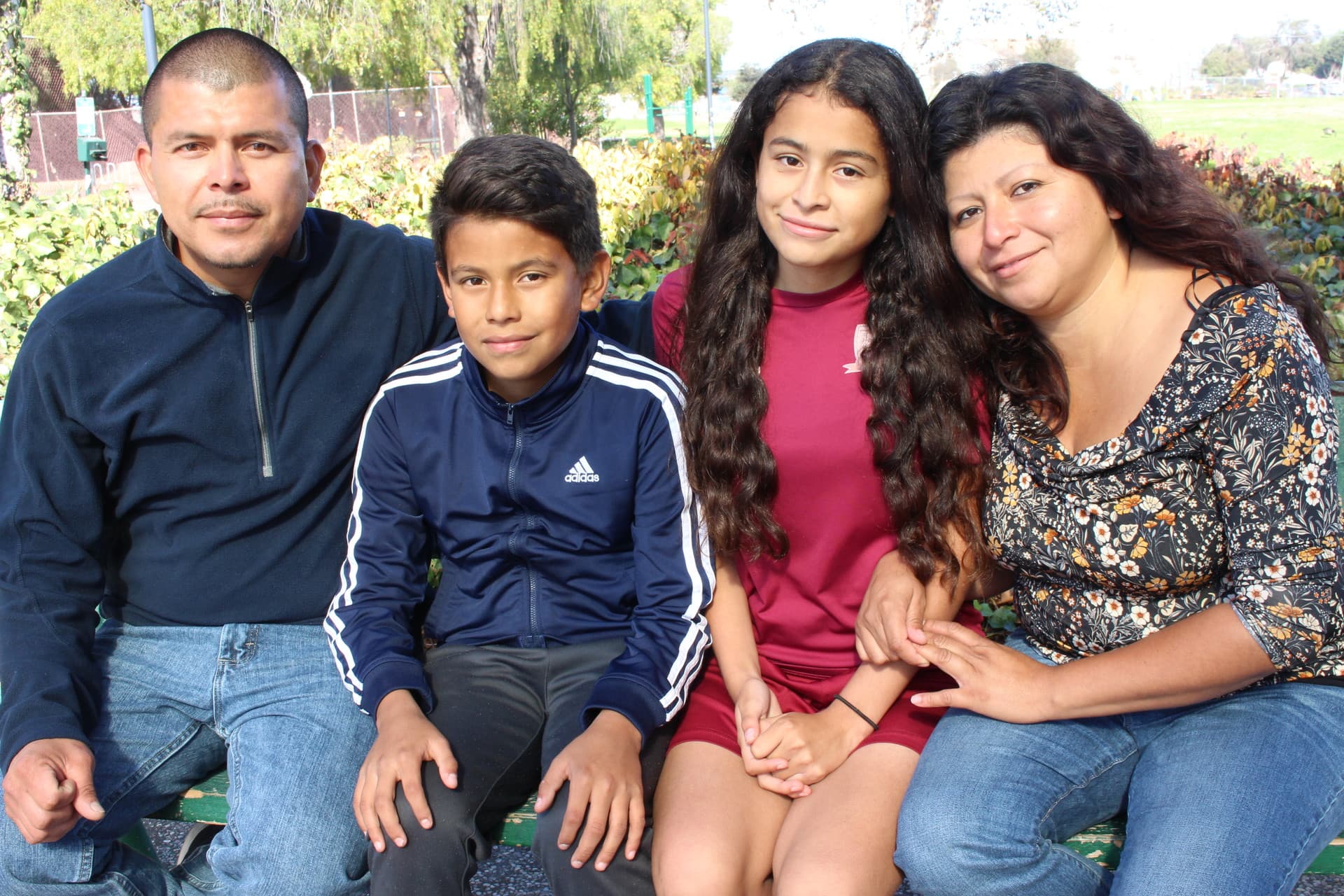 Crista Ramos sits on a park bench with dad Edgar Ramos, brother Diego and mom Cristina Morales in Richmond, California on Nov. 4, 2018.
