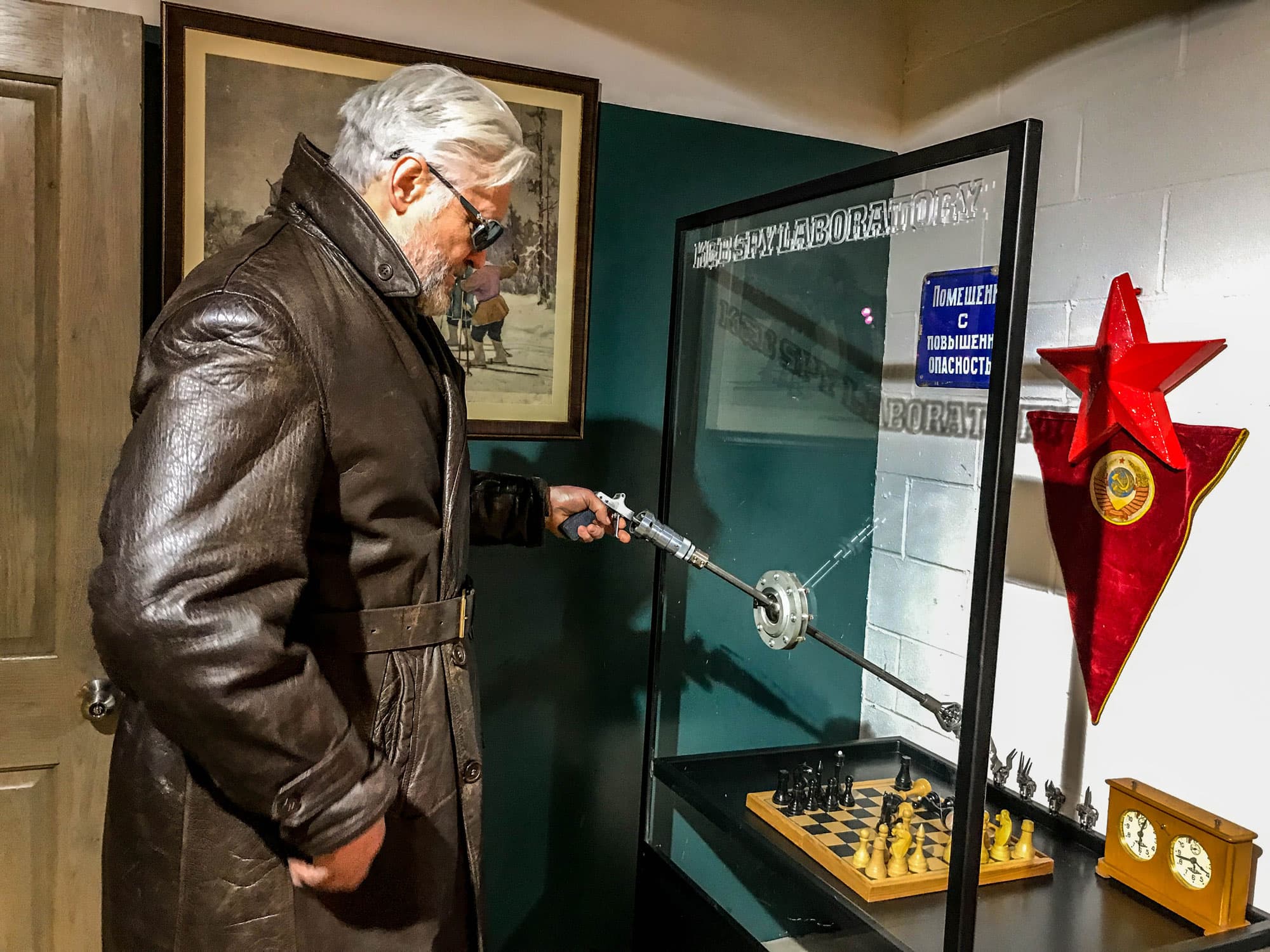 Julius Urbaitis is shown demonstrating a device (reminiscent of arcade claw toy-grabber games) that KGB officers used to mix poison without contaminating themselves.