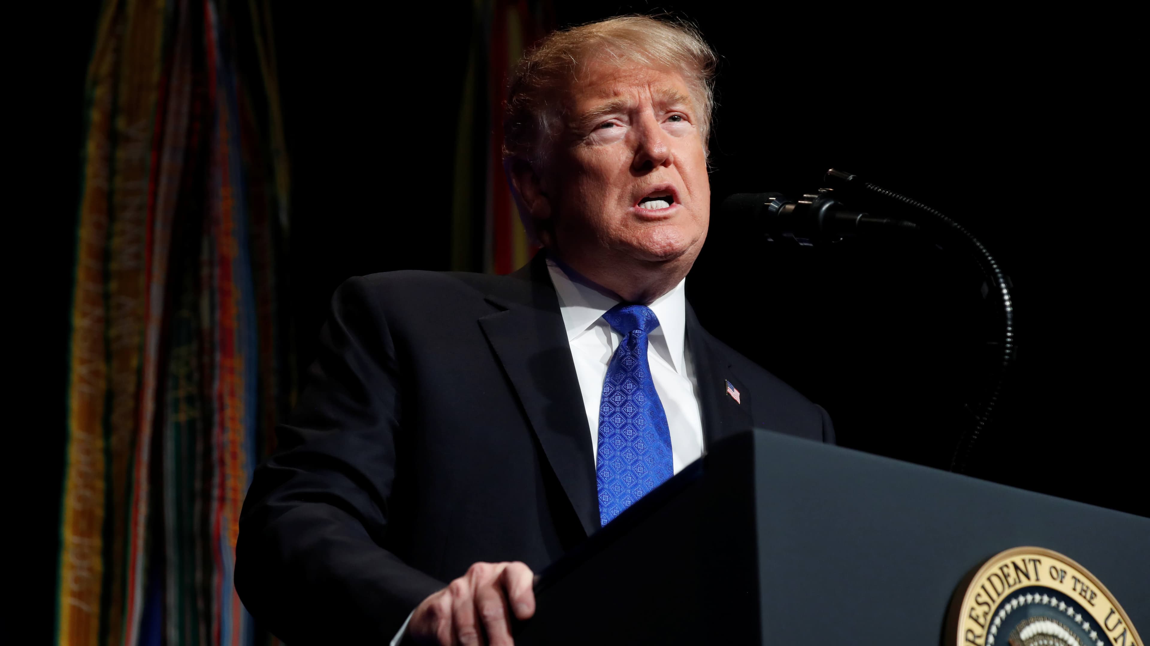 President Donald Trump stands and speaks at a podium