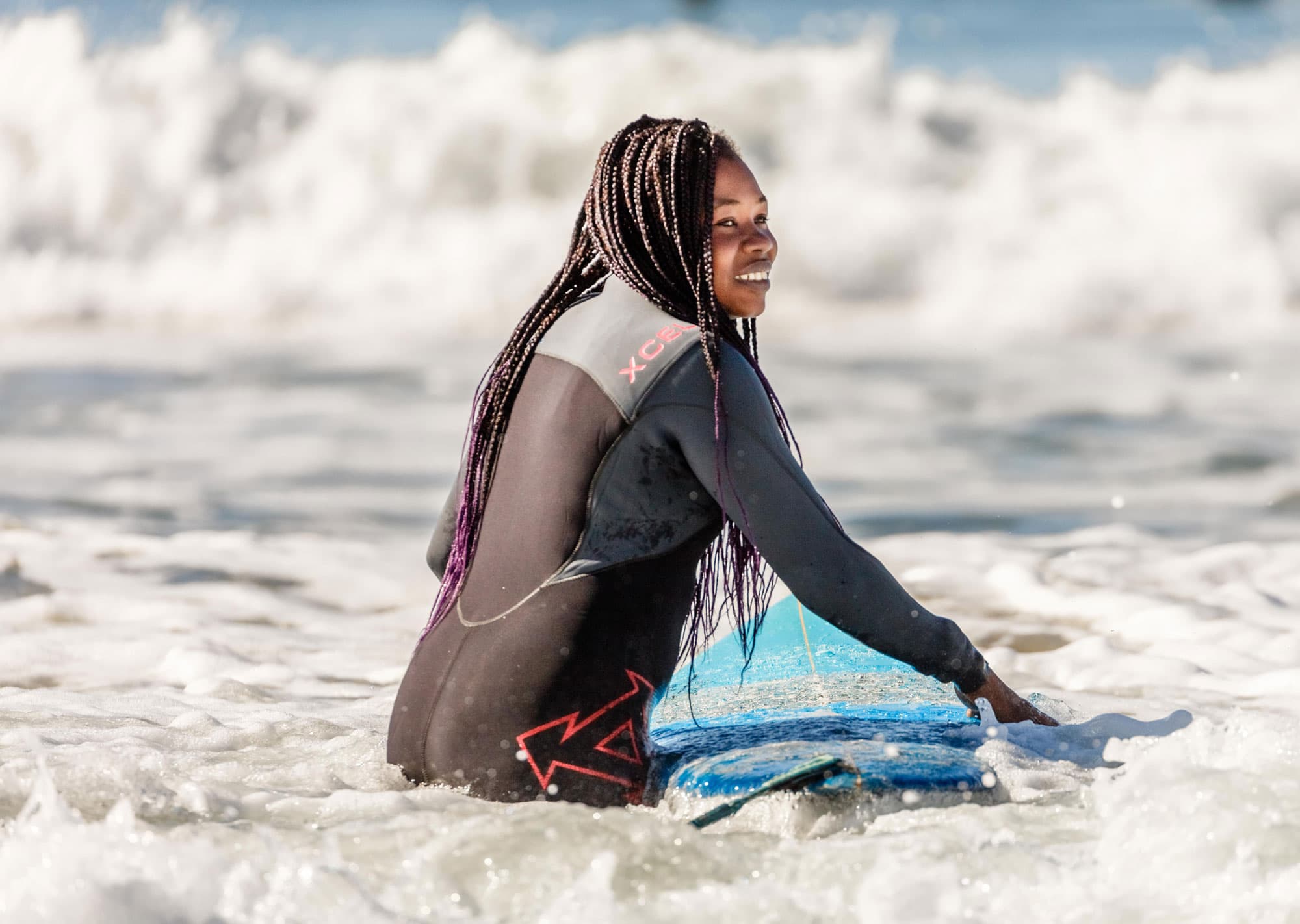 A woman is walking in the ocean water heading back out.