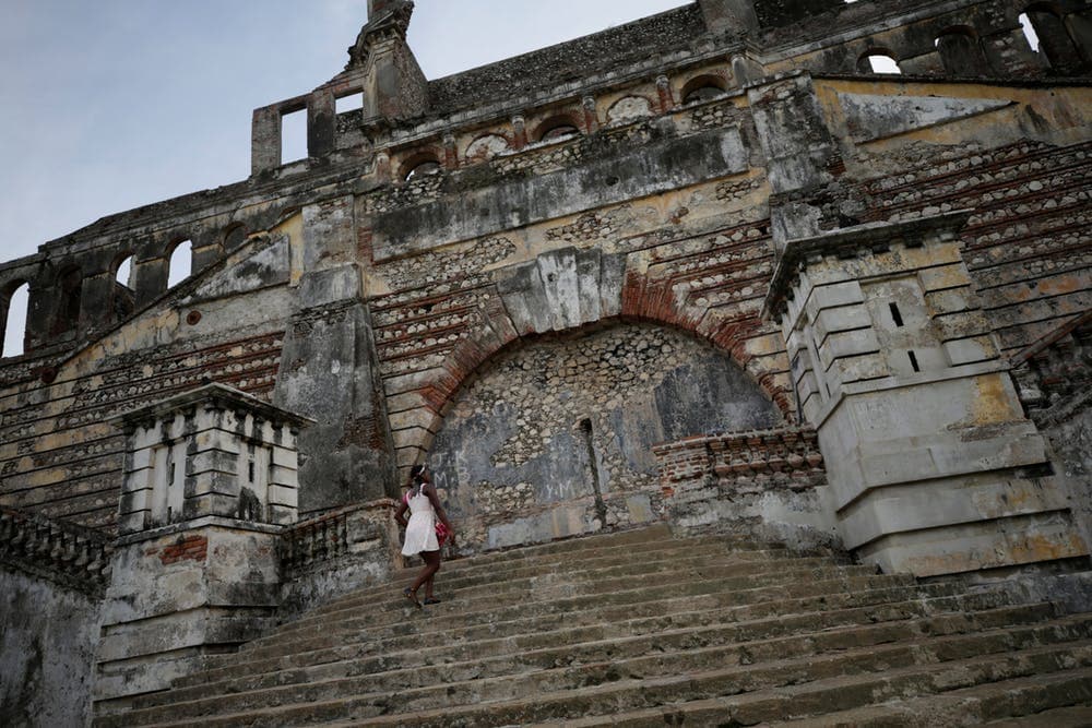 A woman climbs old stone stairs