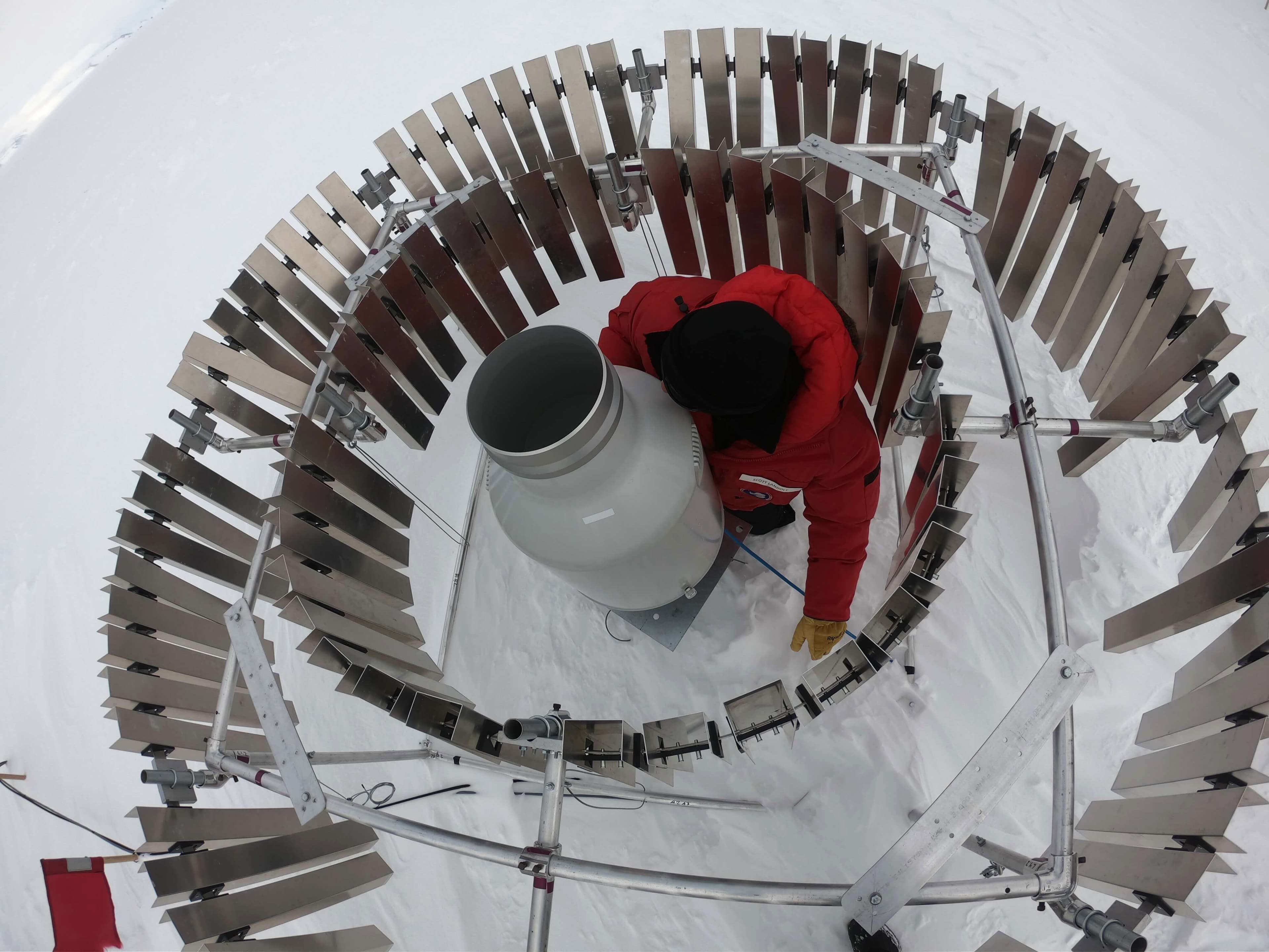 Metallic fins encircle a man in a red coat