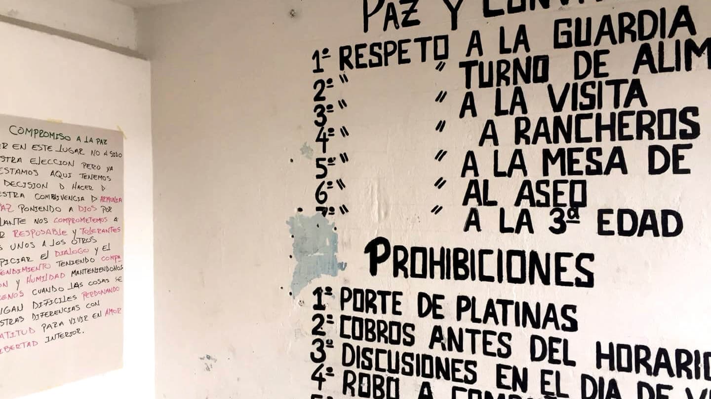 Writing in Spanish on a white wall.