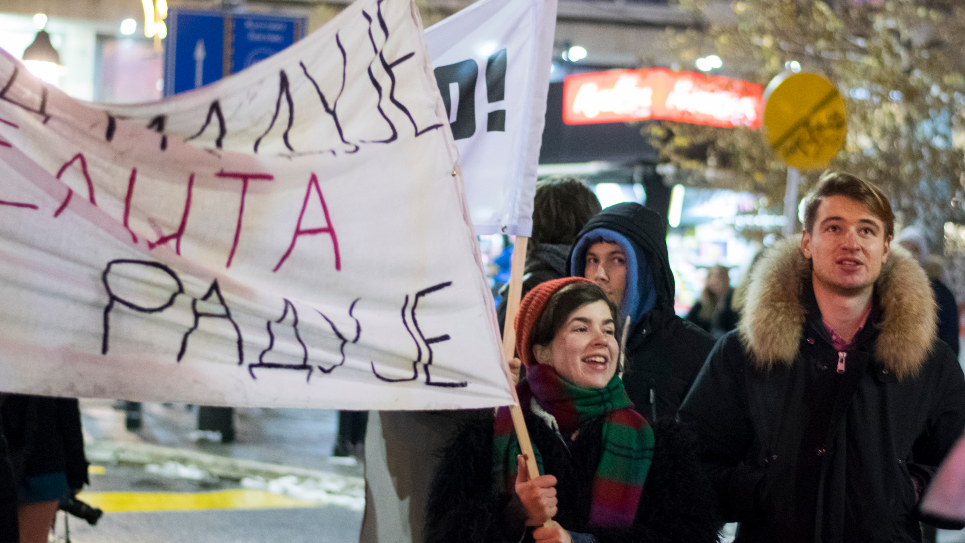 Protesters carry a hand-painted sign.