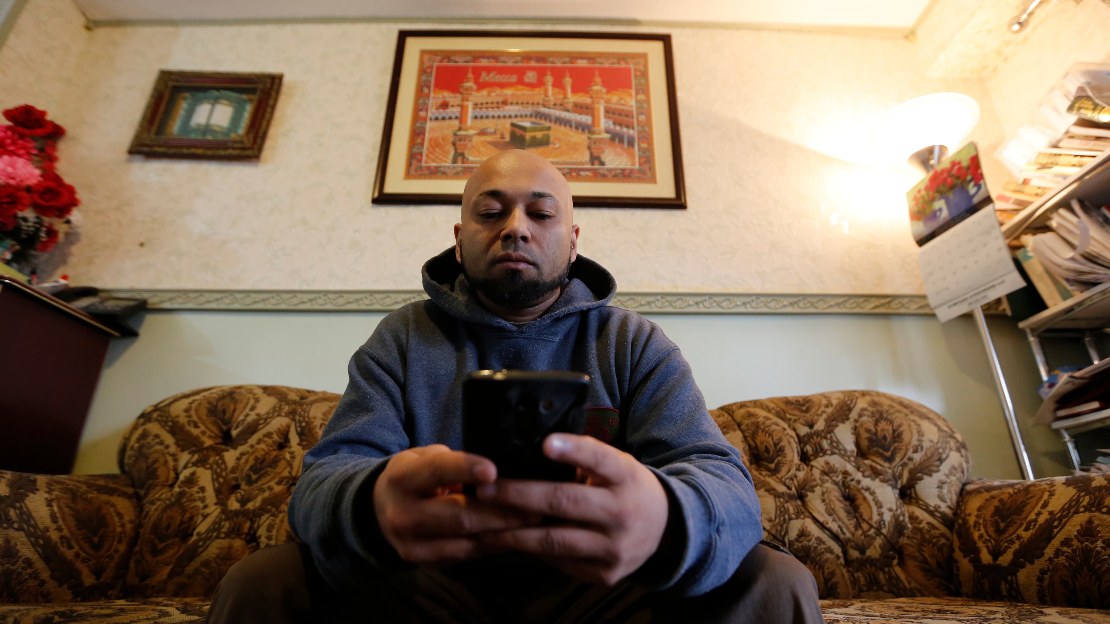 A man sits on a couch in his living room.