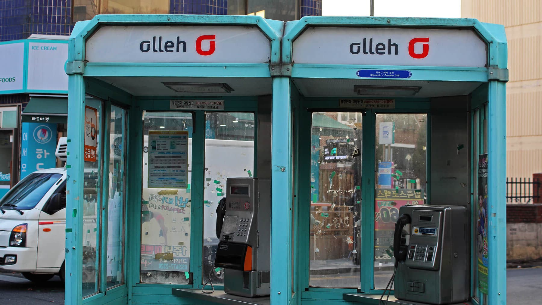 Two old turquoise phone booths side by side in South Korea.