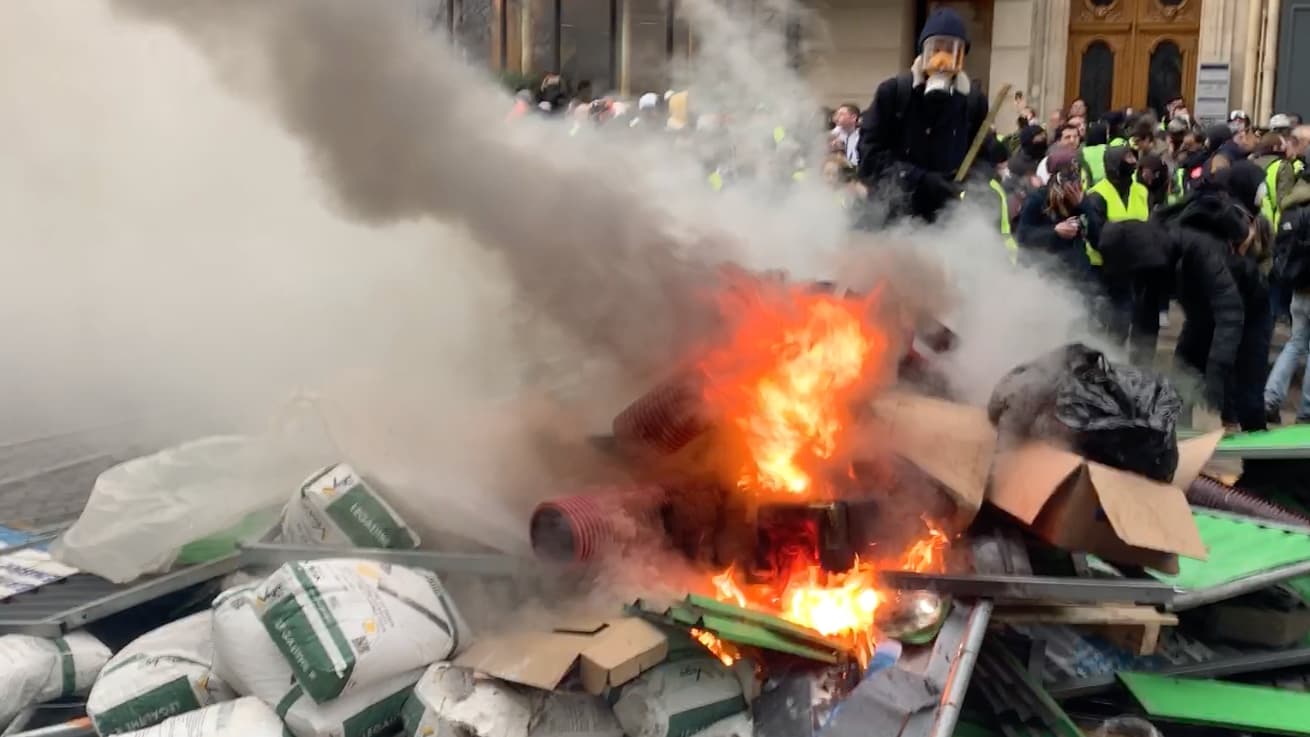 Protesters set fire to a pile of boxes.