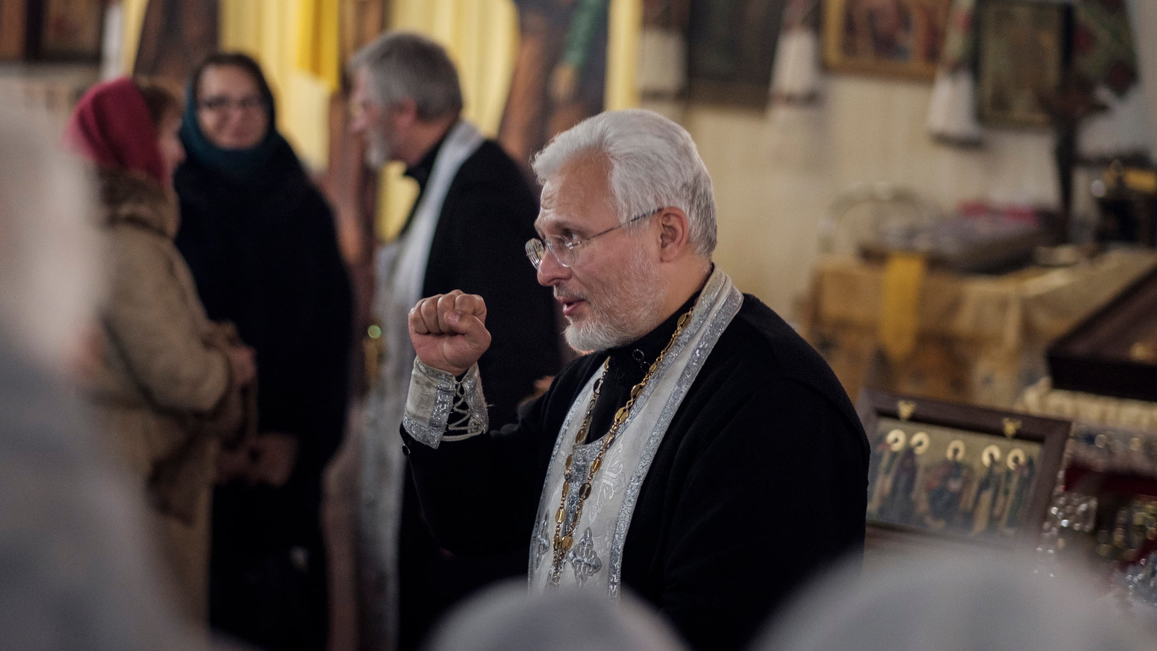 A priest makes a fist.
