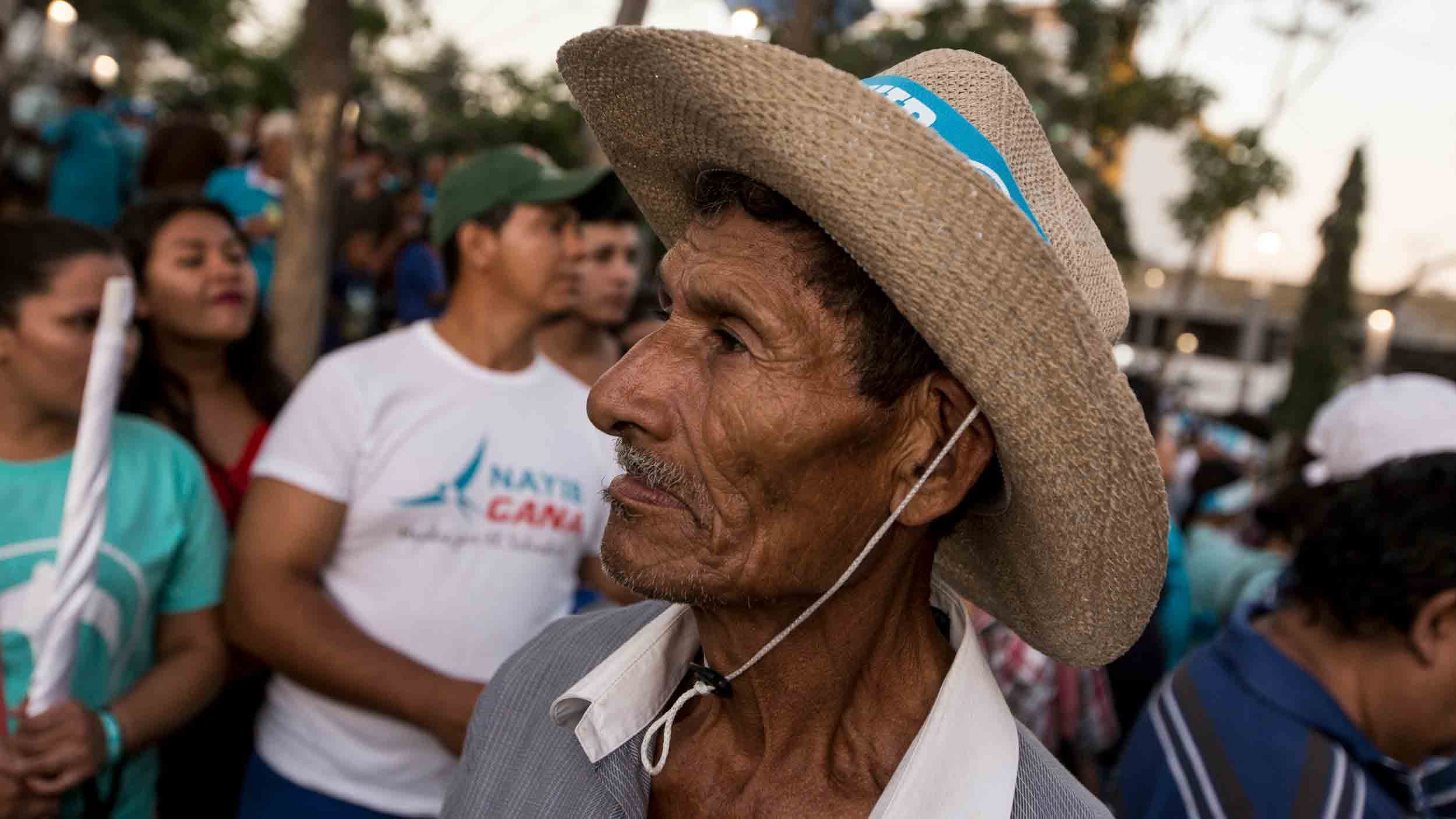 An older man at a political rally in San Salvador.