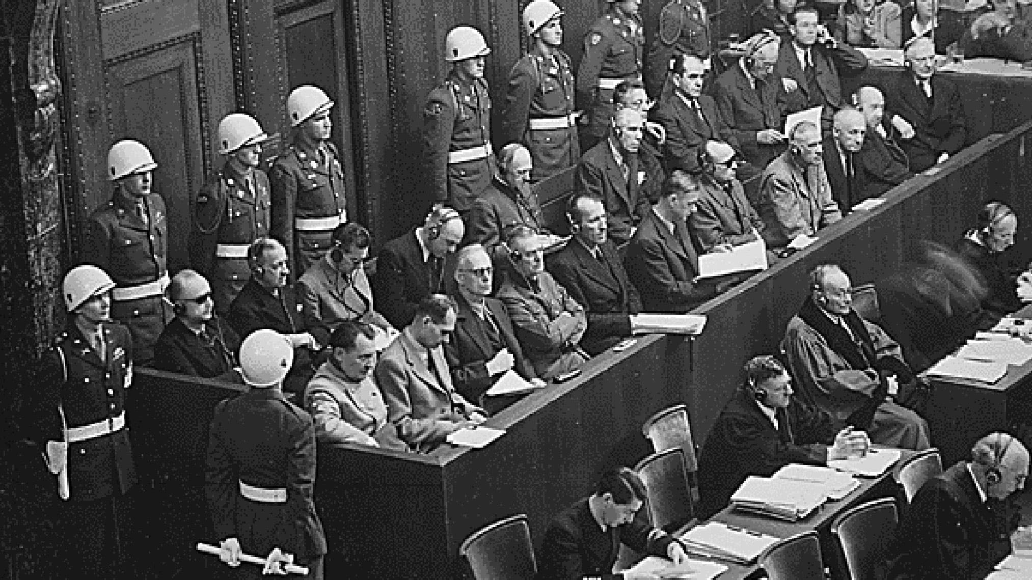 Defendents sit in a juror box and at tables during the Nuremberg trials in this historic photo