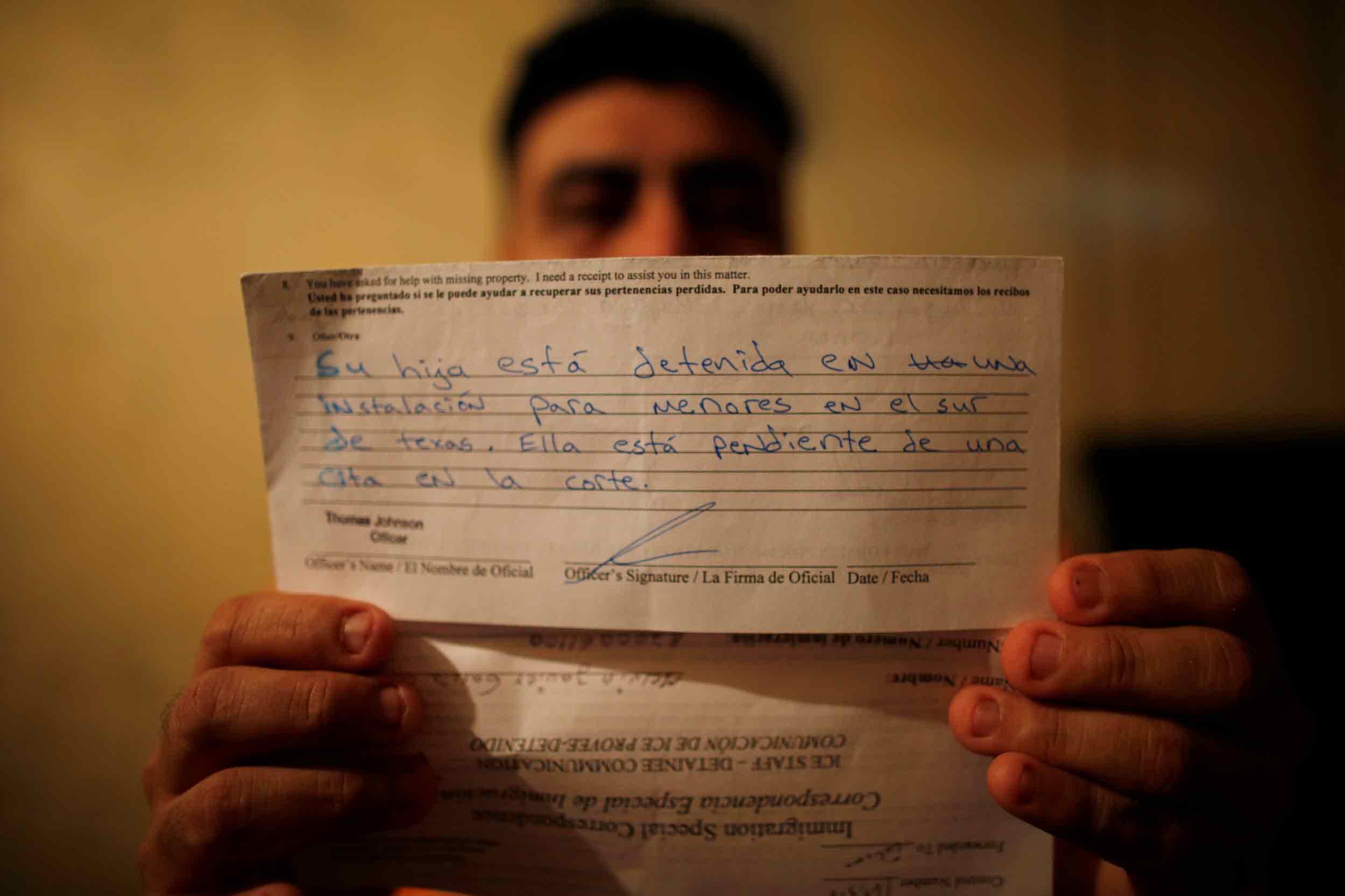 A man holds a letter written in Spanish that tells him his daughter is in a detention center awaiting a trial.