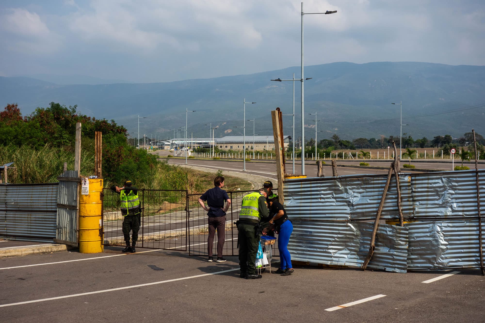 Police stand near a barricaded bridge.